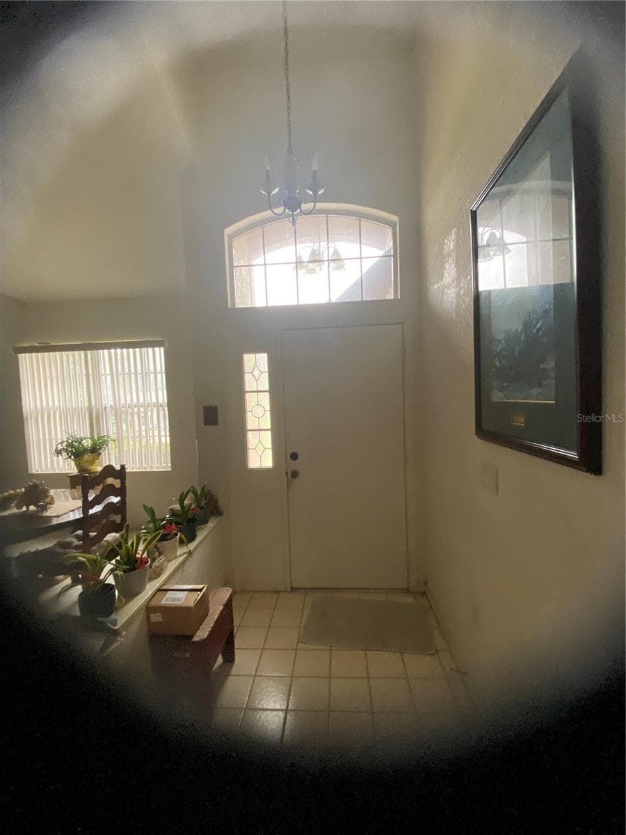 Front door of the house tiles flooring in this area, High ceiling, and large window above the front door. - 11492 SW 82ND COURT RD, OCALA
