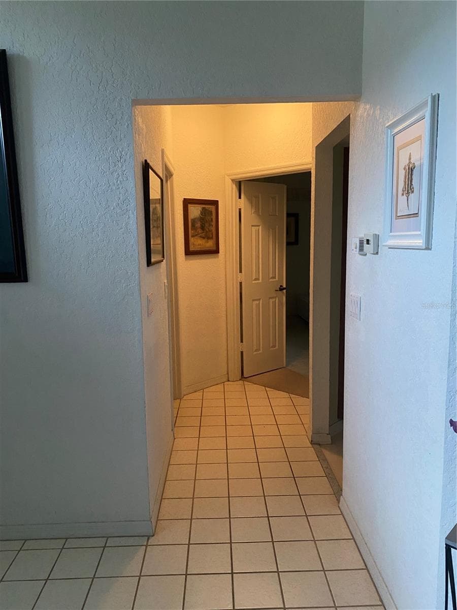 Hallway to the primary bedroom. Tiles flooring area. - 11492 SW 82ND COURT RD, OCALA