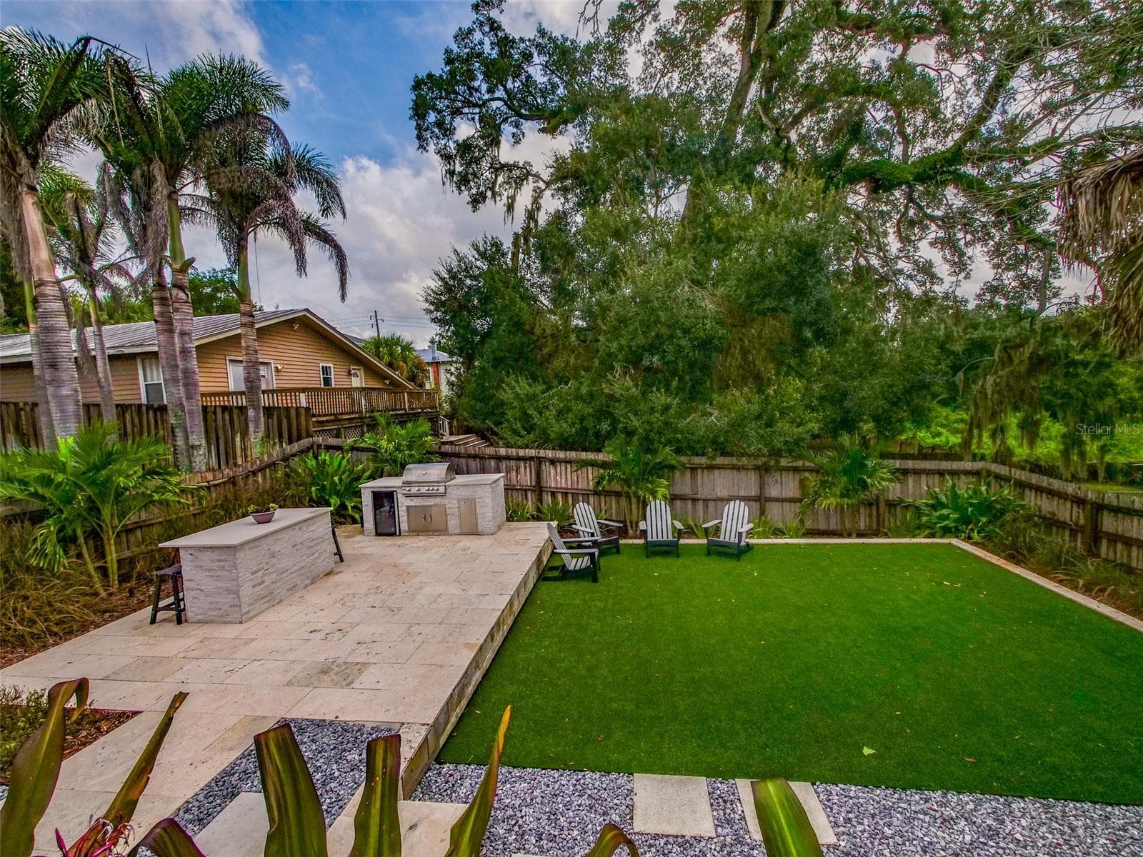 Backyard with outdoor kitchen, turf, and mature tree canopy - 11 S LAWSONA BLVD, ORLANDO