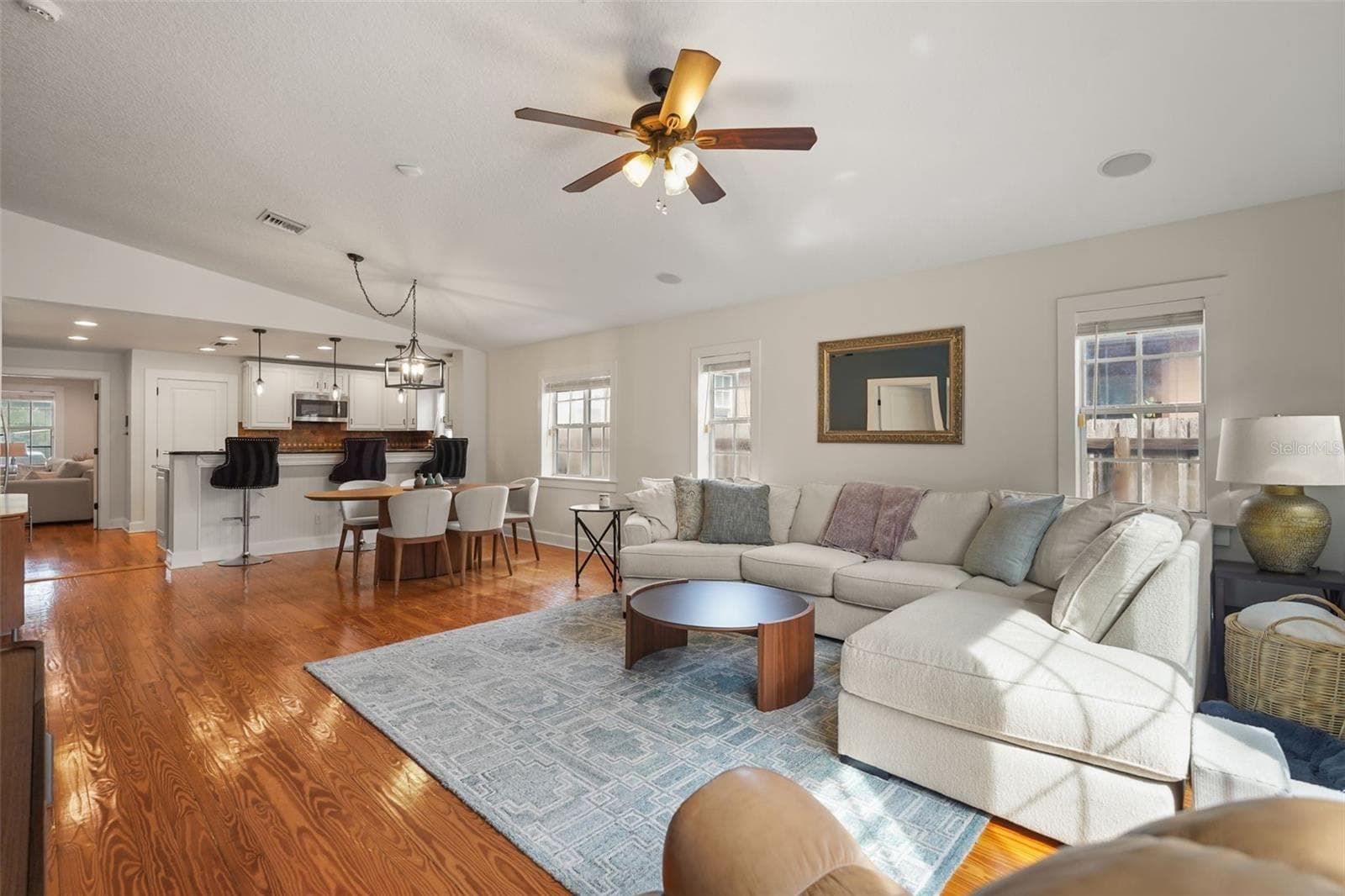 Living room with vaulted ceiling open to the dining area and kitchen - 11 S LAWSONA BLVD, ORLANDO
