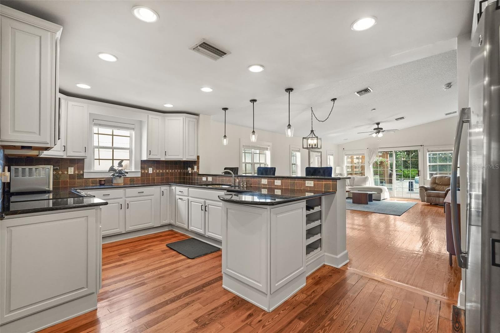 Kitchen open to the living room with sliding glass doors to the rear deck - 11 S LAWSONA BLVD, ORLANDO