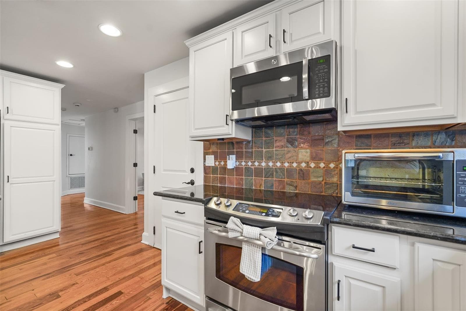 Kitchen range and cabinetry with hallway view - 11 S LAWSONA BLVD, ORLANDO