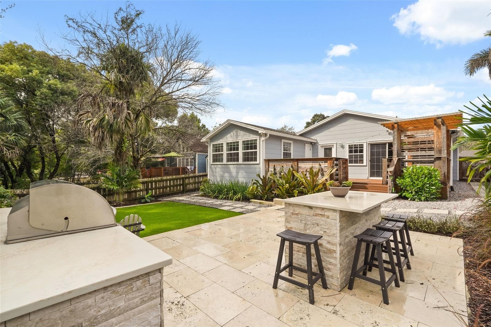 Outdoor kitchen with bar seating and view of the rear exterior - 11 S LAWSONA BLVD, ORLANDO