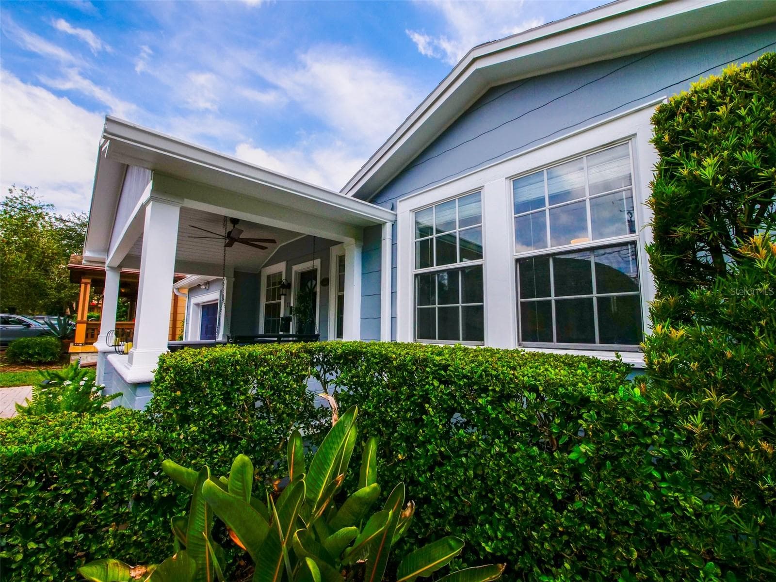 Covered front porch and front windows with landscaped hedges - 11 S LAWSONA BLVD, ORLANDO