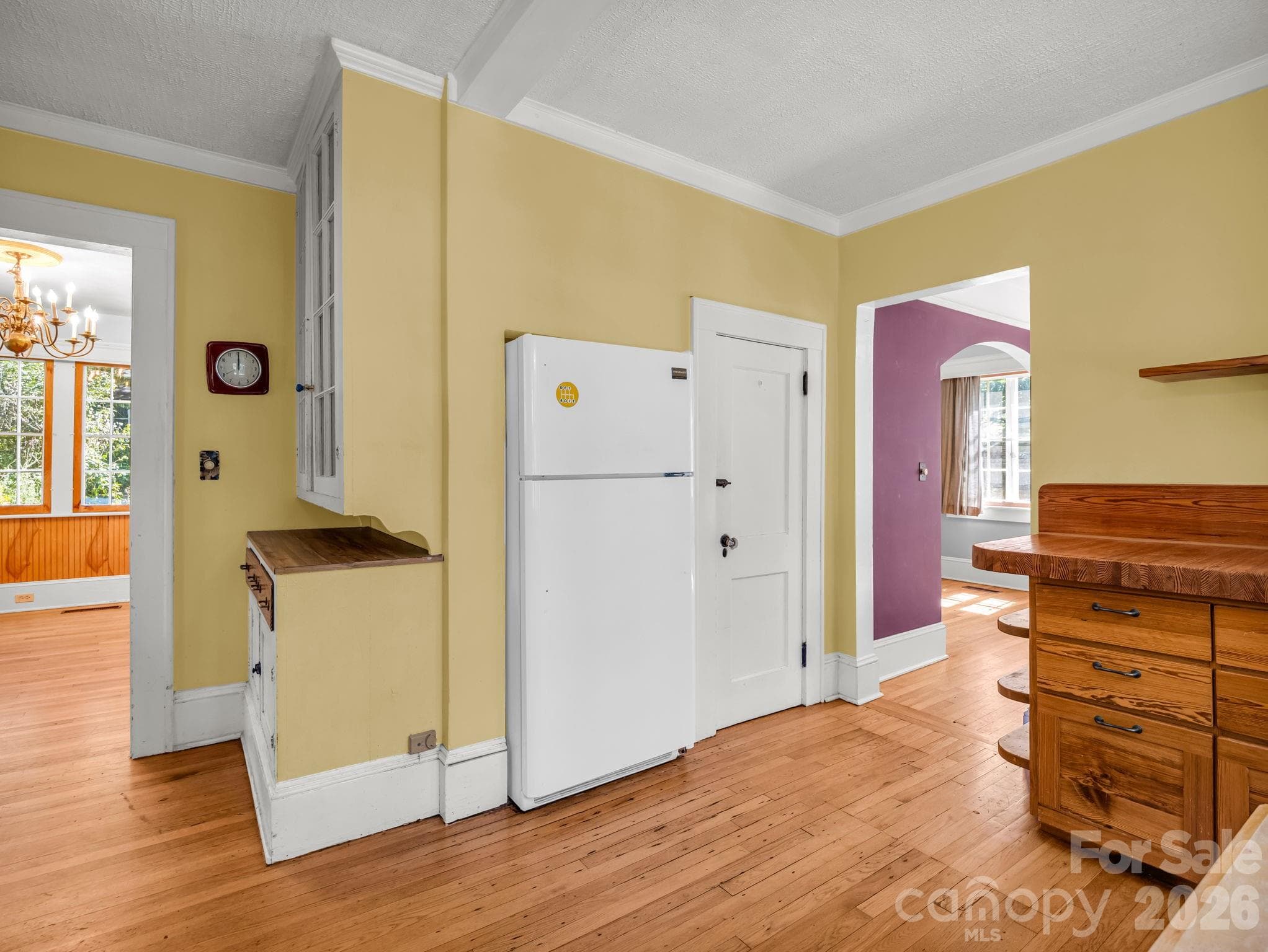 The inviting kitchen features heart-pine cabinetry, a custom butcher-block countertop crafted by Lloyd Nelson, and distinctive tile designed by Jay Reese - 323 Blythe Street, Hendersonville