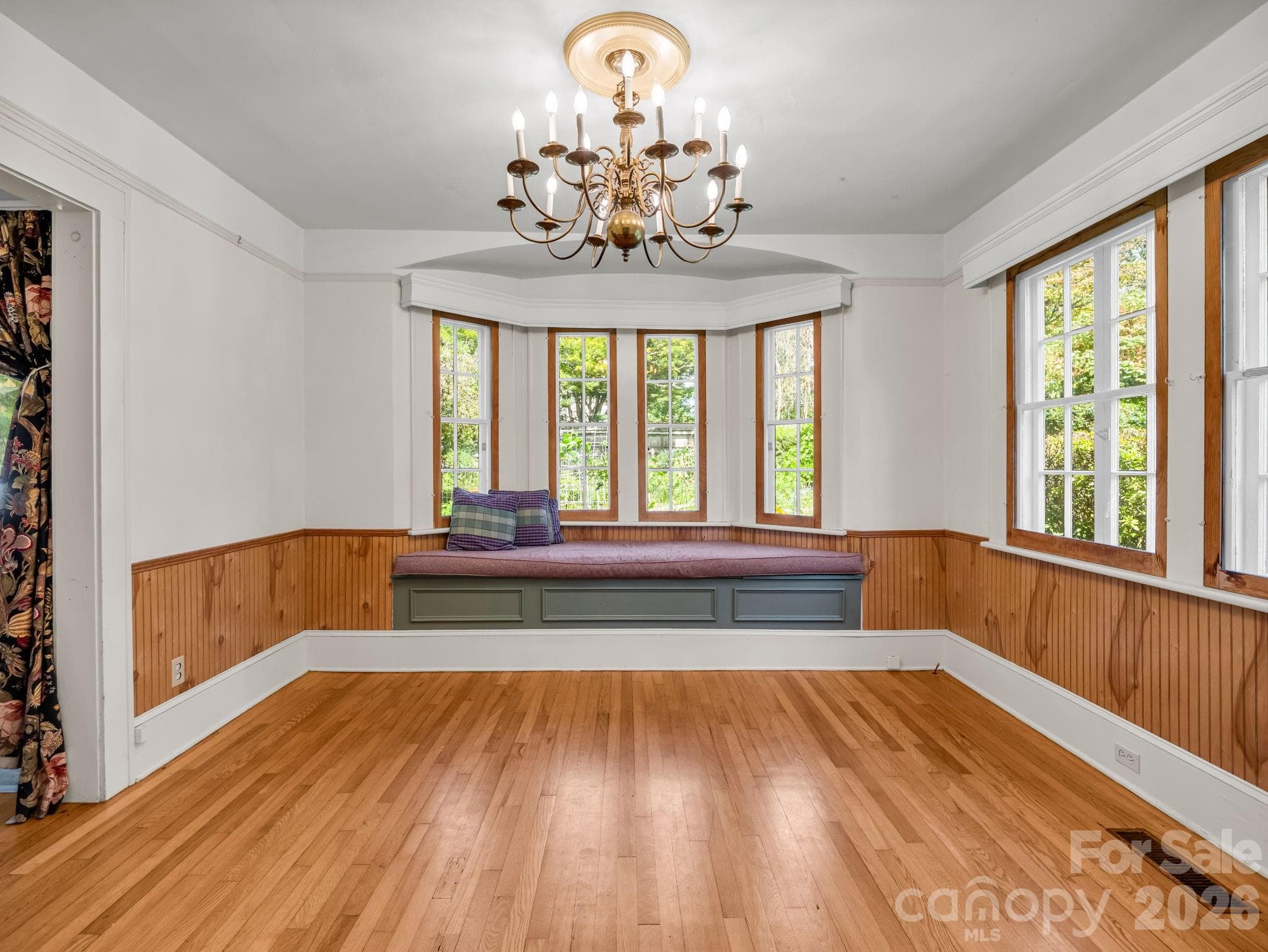 Formal dining room with bay window and storage, beautiful chandelier and abundant natural light - 323 Blythe Street, Hendersonville