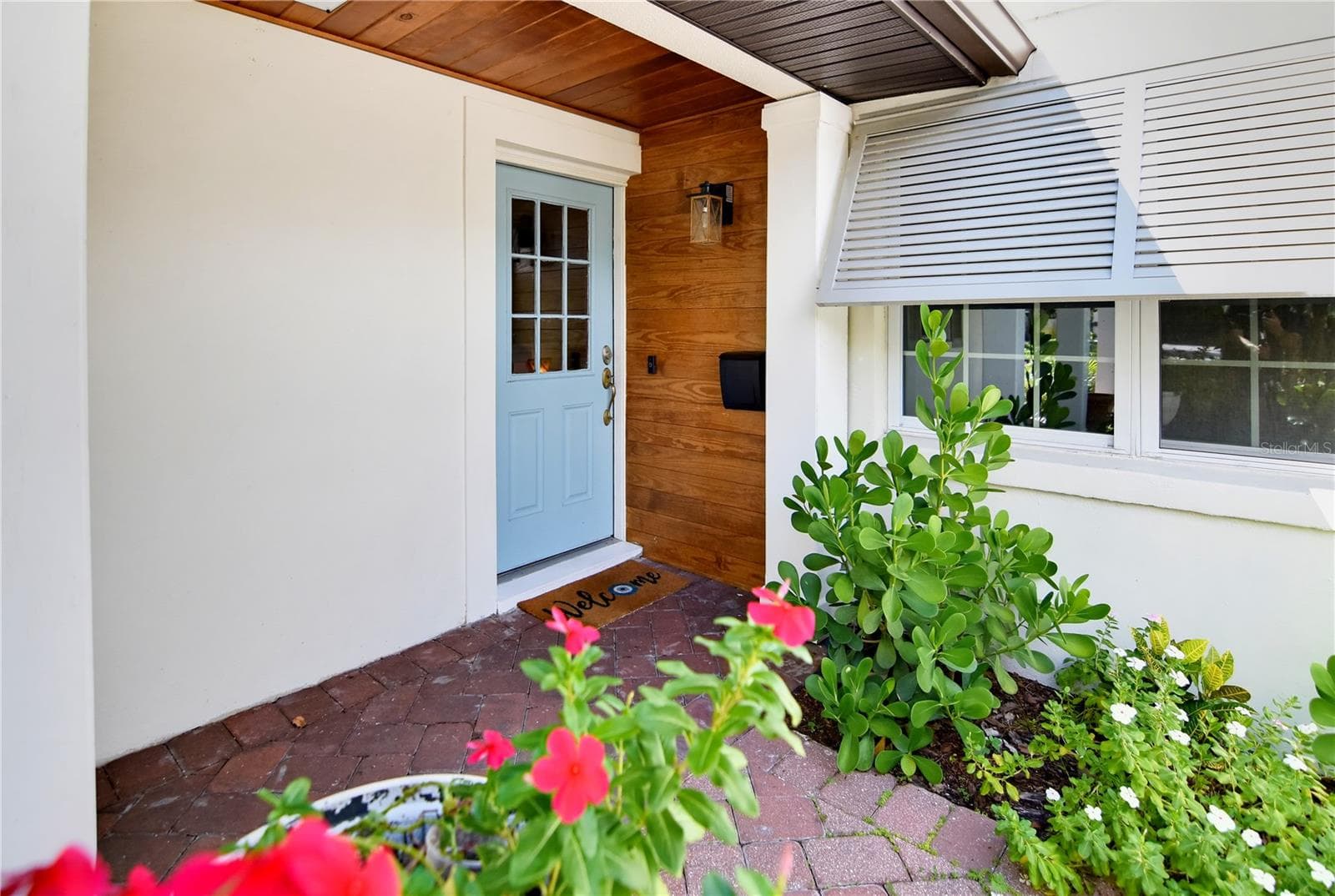 Welcoming covered front entry with attractive architectural details and lush landscaping. - 1611 CHESTNUT AVE, WINTER PARK