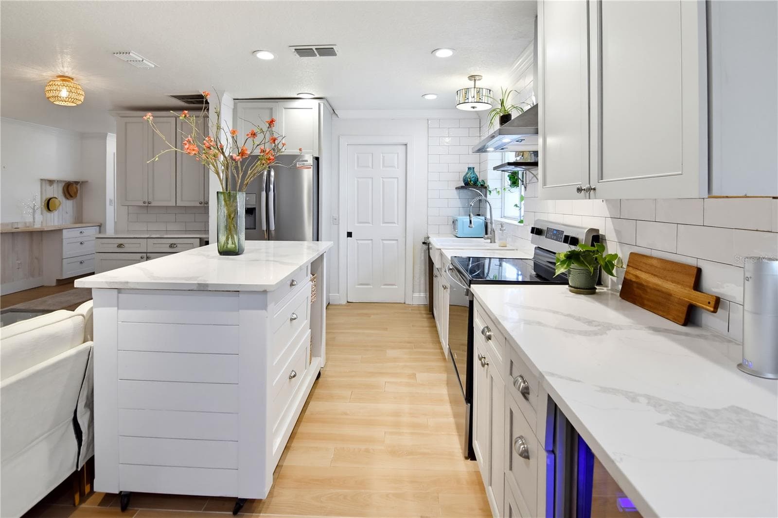 Updated kitchen featuring quartz countertops, stainless steel appliances, and a spacious center island. - 1611 CHESTNUT AVE, WINTER PARK