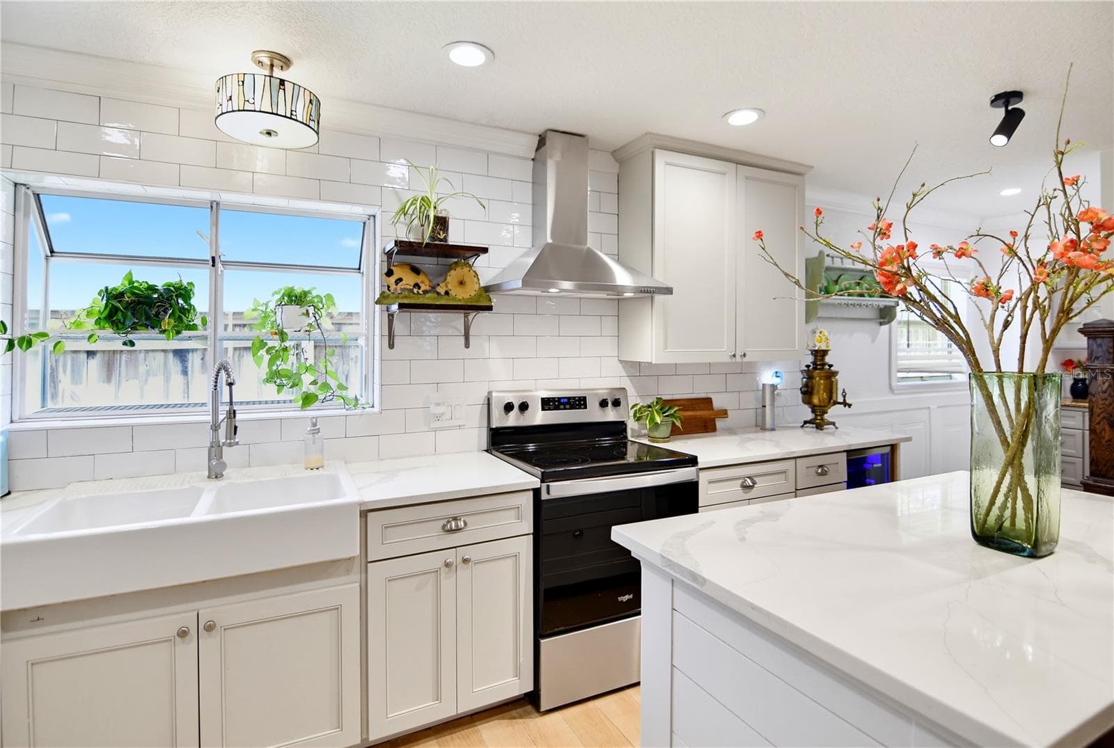 Bright kitchen with farmhouse sink, stainless steel appliances, and attractive cabinetry. - 1611 CHESTNUT AVE, WINTER PARK