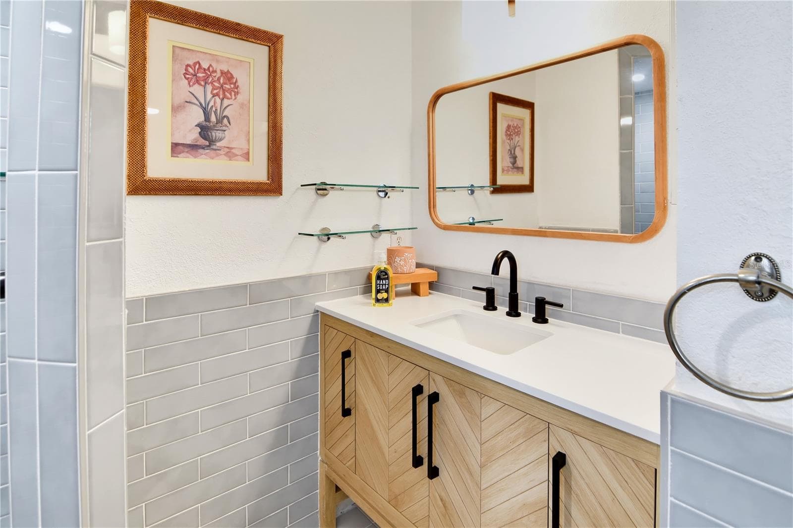 Stylish bathroom vanity with modern fixtures, attractive tilework, and generous counter space. - 1611 CHESTNUT AVE, WINTER PARK