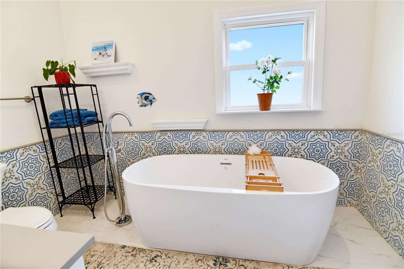 Primary bathroom featuring a freestanding soaking tub and decorative tile accents. - 1611 CHESTNUT AVE, WINTER PARK