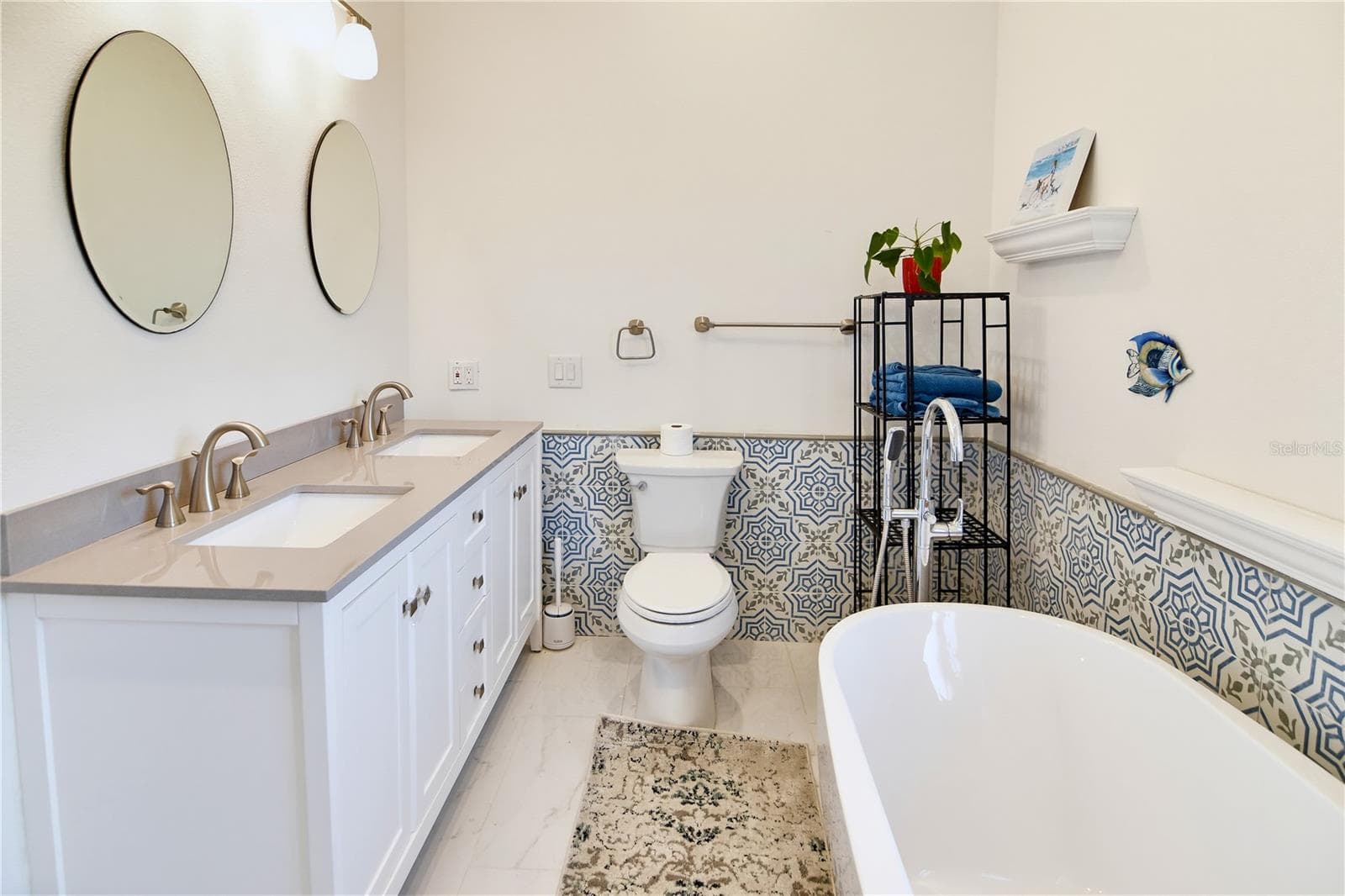 Spacious primary bathroom with double vanity, soaking tub, and beautifully coordinated finishes. - 1611 CHESTNUT AVE, WINTER PARK