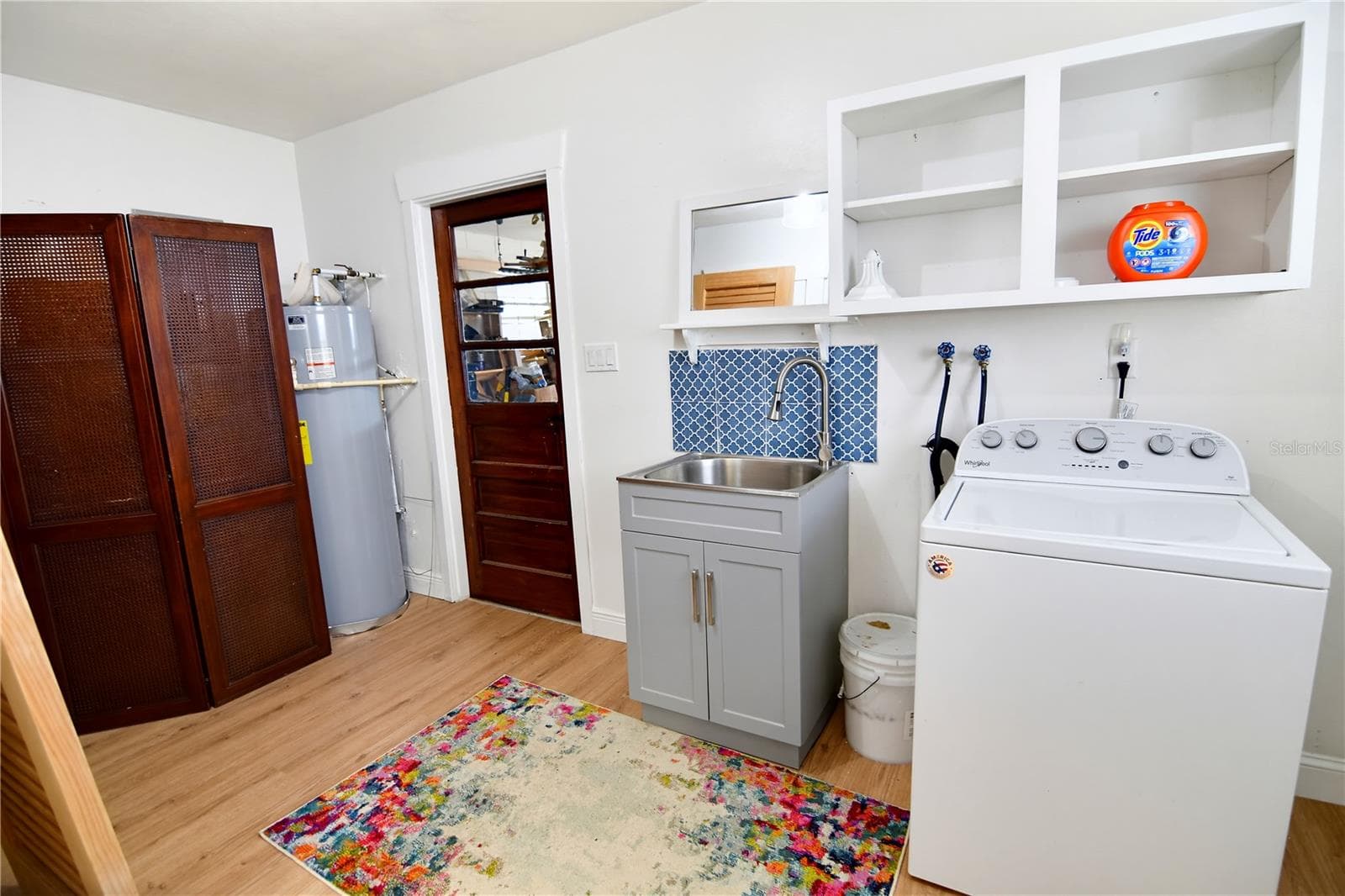 Dedicated laundry room with washer, dryer, utility sink, and built-in storage. - 1611 CHESTNUT AVE, WINTER PARK