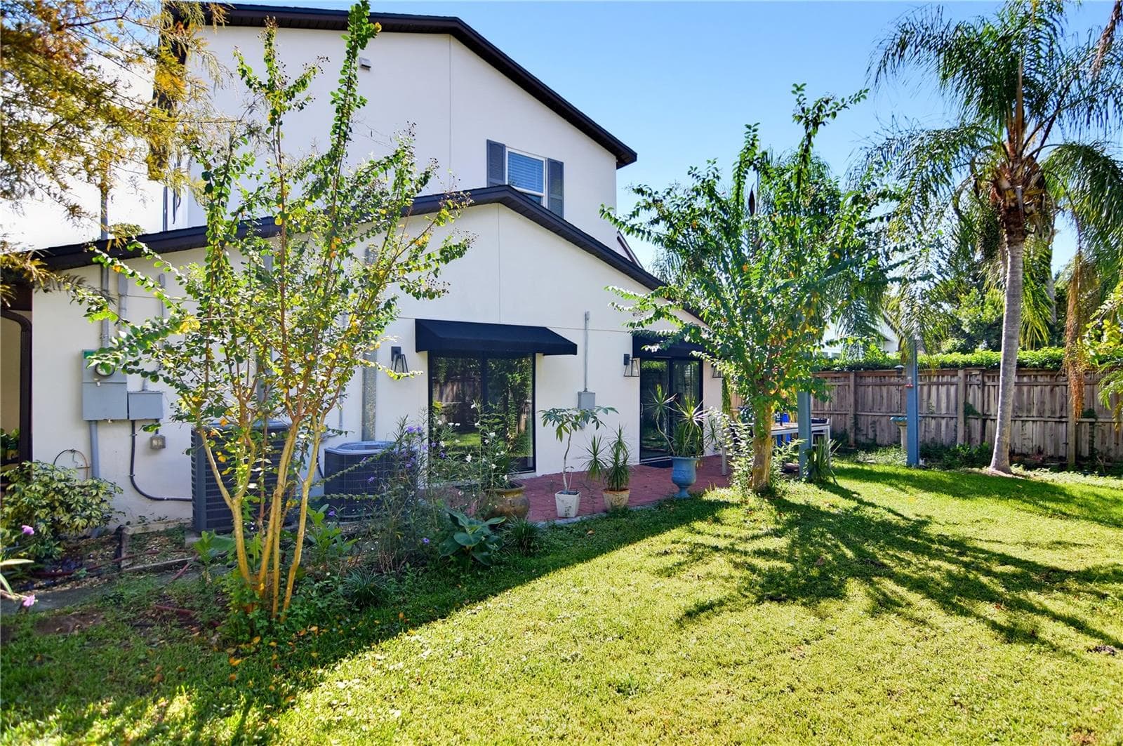 Another backyard perspective highlighting the landscaped grounds and outdoor living space. - 1611 CHESTNUT AVE, WINTER PARK