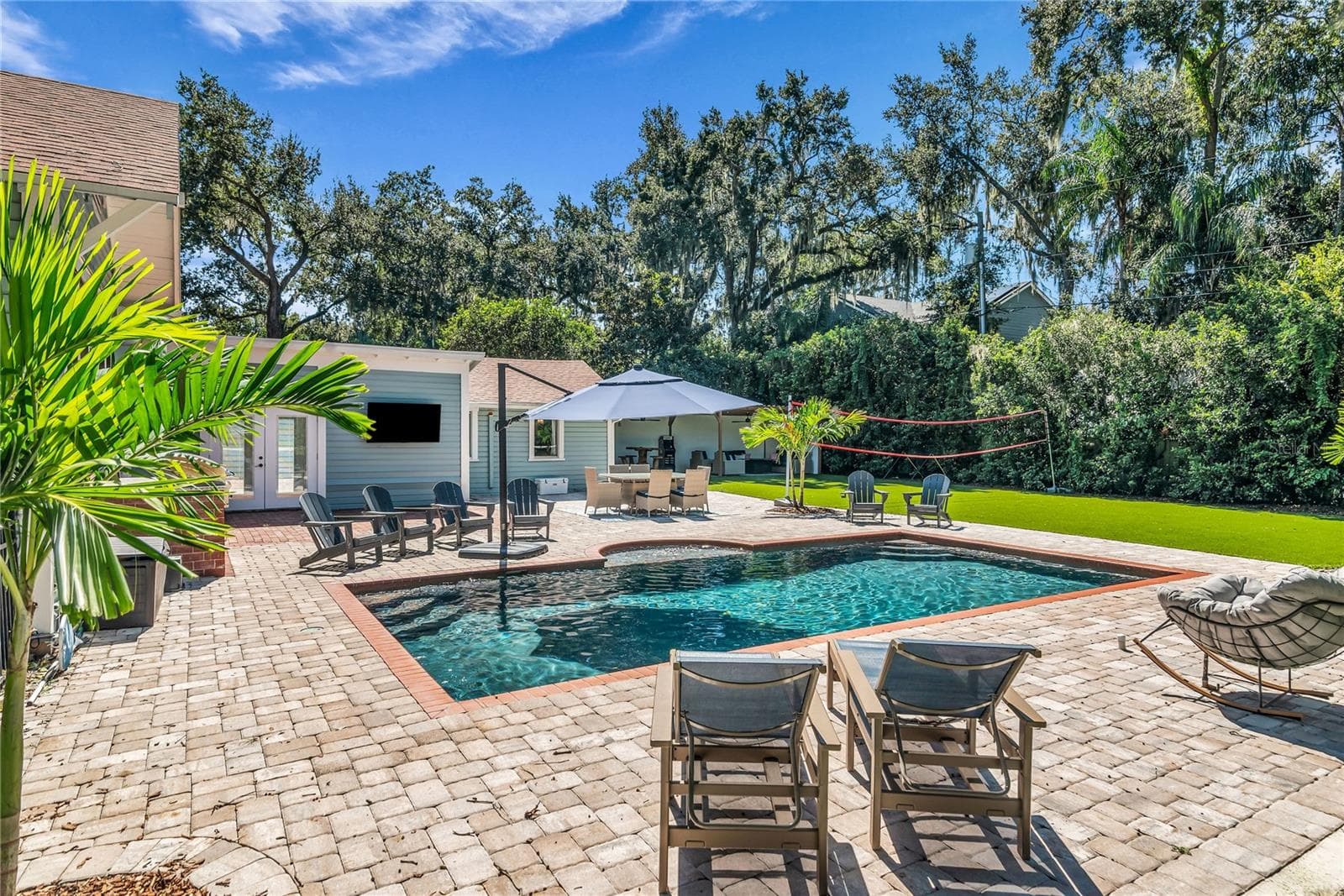 The enormous fully fenced backyard is designed for year-round enjoyment with a gas-heated saltwater sport pool, outdoor kitchen, expansive brick paved deck, detached covered lanai, and low-maintenance turf. - 234 N LAKEVIEW AVE, WINTER GARDEN