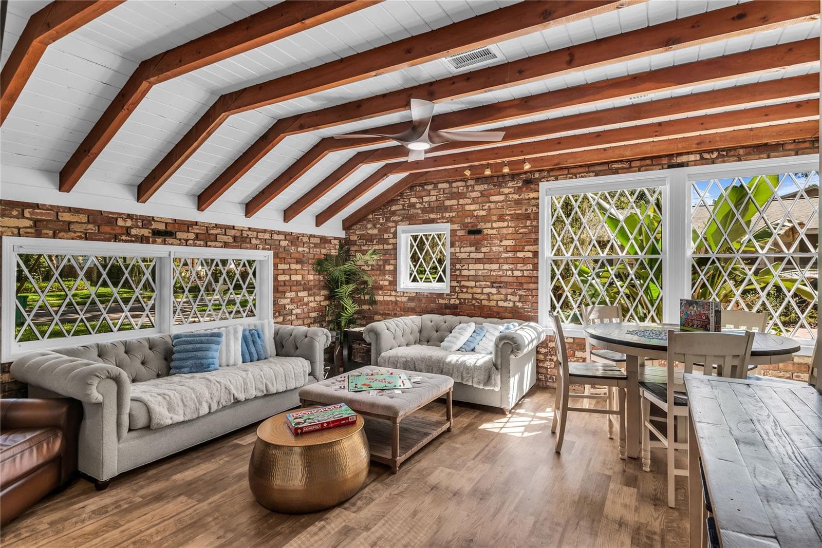 Natural light pours into the spacious family room that features warm brick walls, exposed wood beams and distinctive diamond-pane windows that create a timeless architectural backdrop. - 234 N LAKEVIEW AVE, WINTER GARDEN