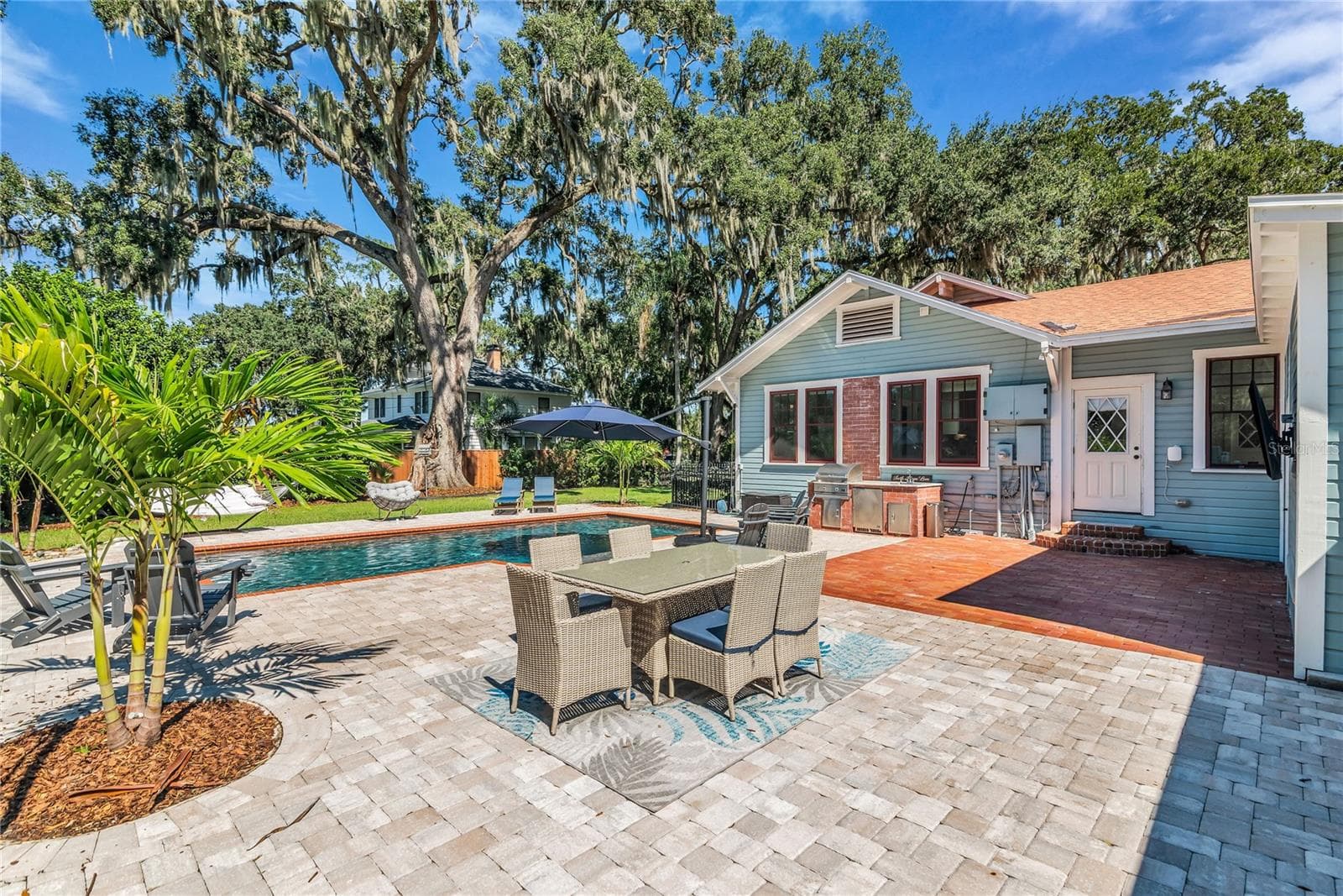 The enormous fully fenced backyard is designed for year-round enjoyment with a gas-heated saltwater sport pool, outdoor kitchen, expansive brick paved deck, detached covered lanai, and low-maintenance turf. - 234 N LAKEVIEW AVE, WINTER GARDEN