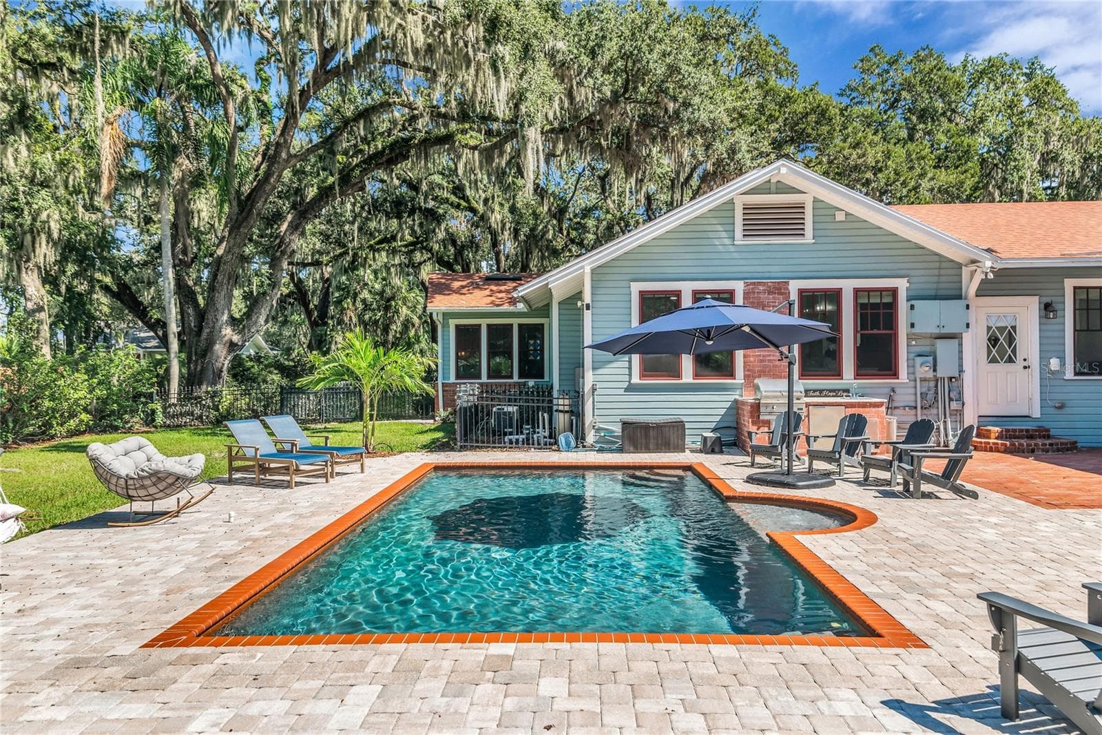 The enormous fully fenced backyard is designed for year-round enjoyment with a gas-heated saltwater sport pool, outdoor kitchen, expansive brick paved deck, detached covered lanai, and low-maintenance turf. - 234 N LAKEVIEW AVE, WINTER GARDEN
