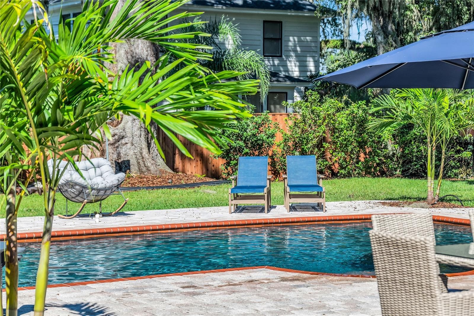 The enormous fully fenced backyard is designed for year-round enjoyment with a gas-heated saltwater sport pool, outdoor kitchen, expansive brick paved deck, detached covered lanai, and low-maintenance turf. - 234 N LAKEVIEW AVE, WINTER GARDEN