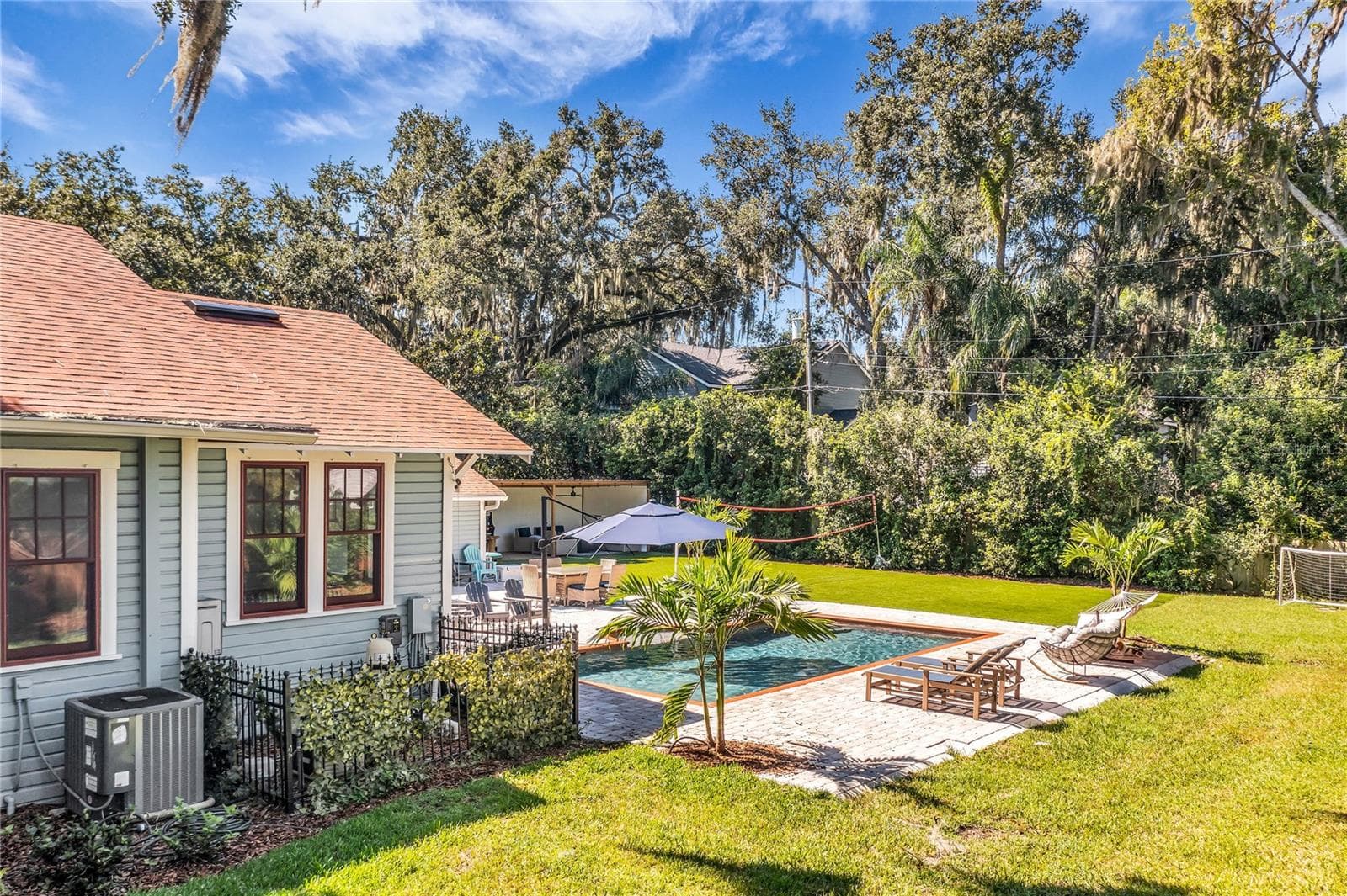 The enormous fully fenced backyard is designed for year-round enjoyment with a gas-heated saltwater sport pool, outdoor kitchen, expansive brick paved deck, detached covered lanai, and low-maintenance turf. - 234 N LAKEVIEW AVE, WINTER GARDEN