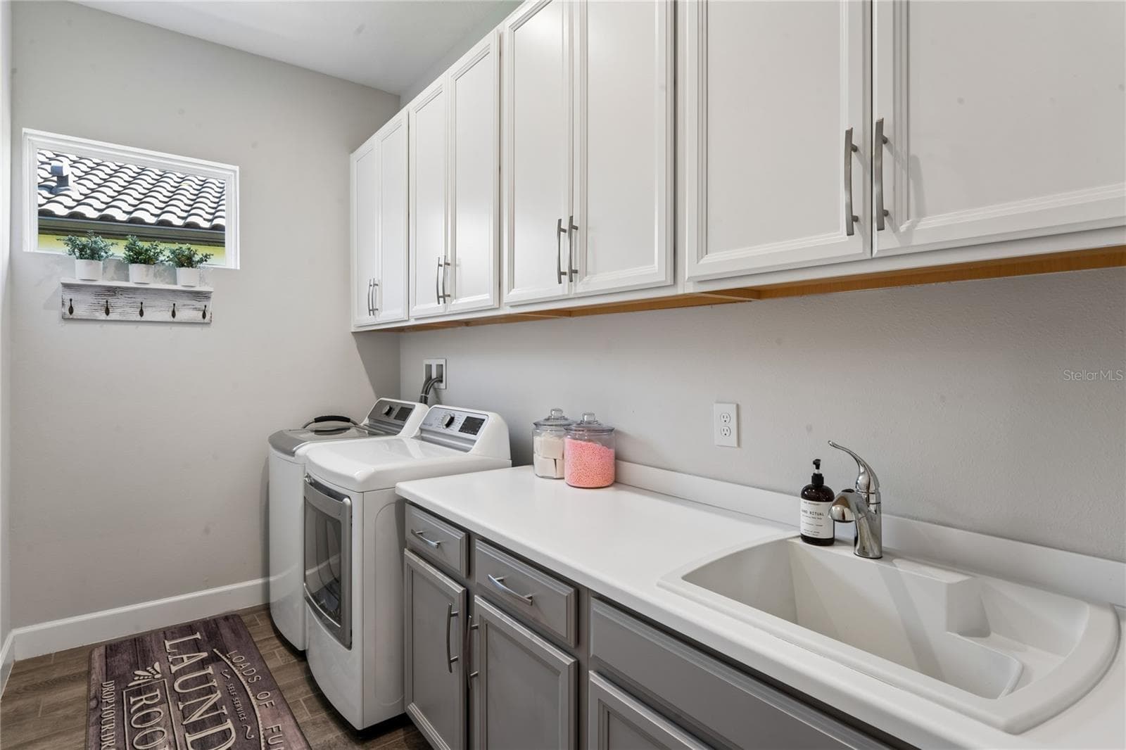 Laundry room with storage cabinets and utility sink - 10813 CALLUNA DR, ODESSA
