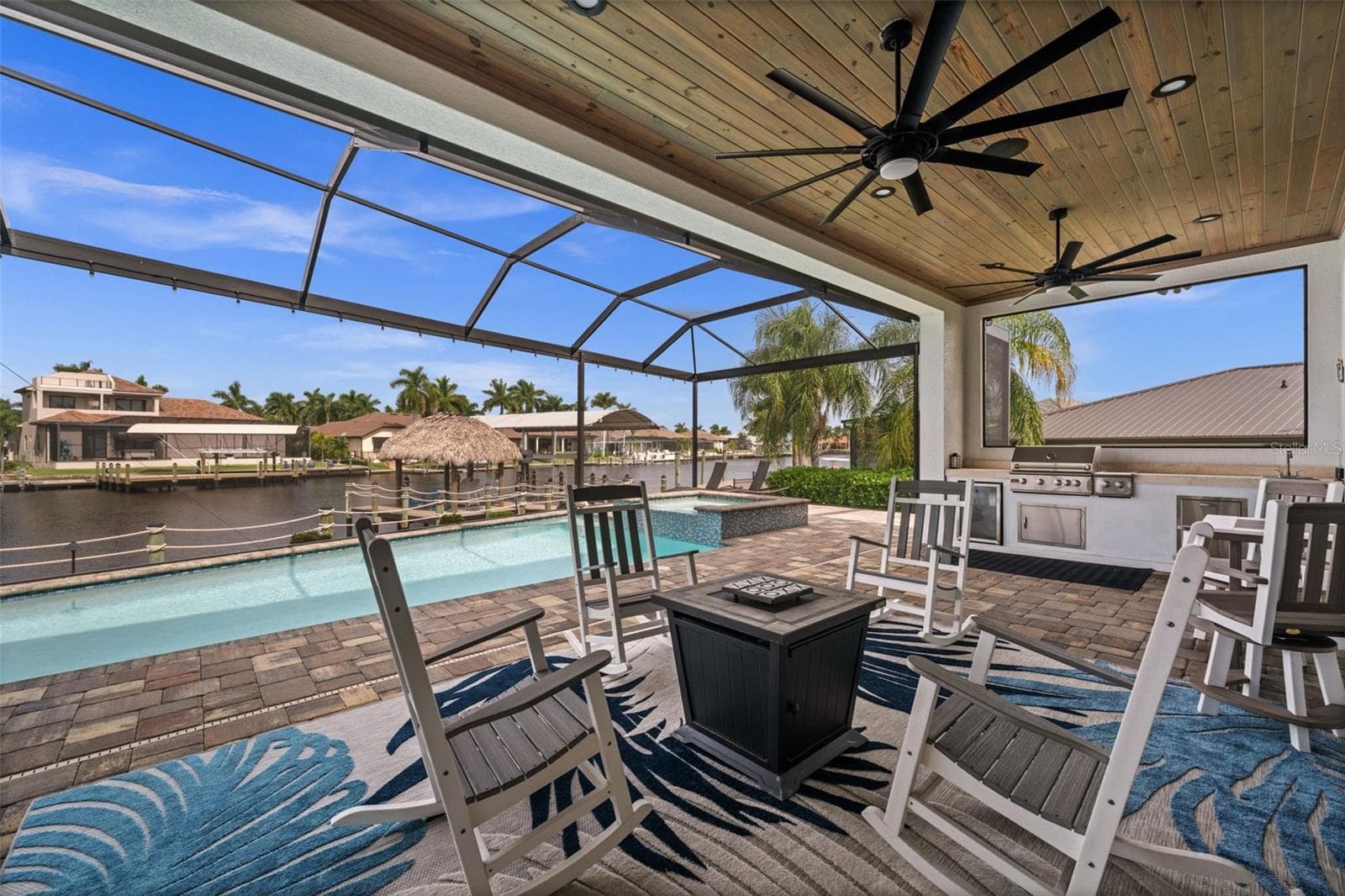 Beautiful details throughout this build. From the wood ceilings in the lanai, to the picture window screen cage with amazing views - 5205 SUNSET CT, CAPE CORAL