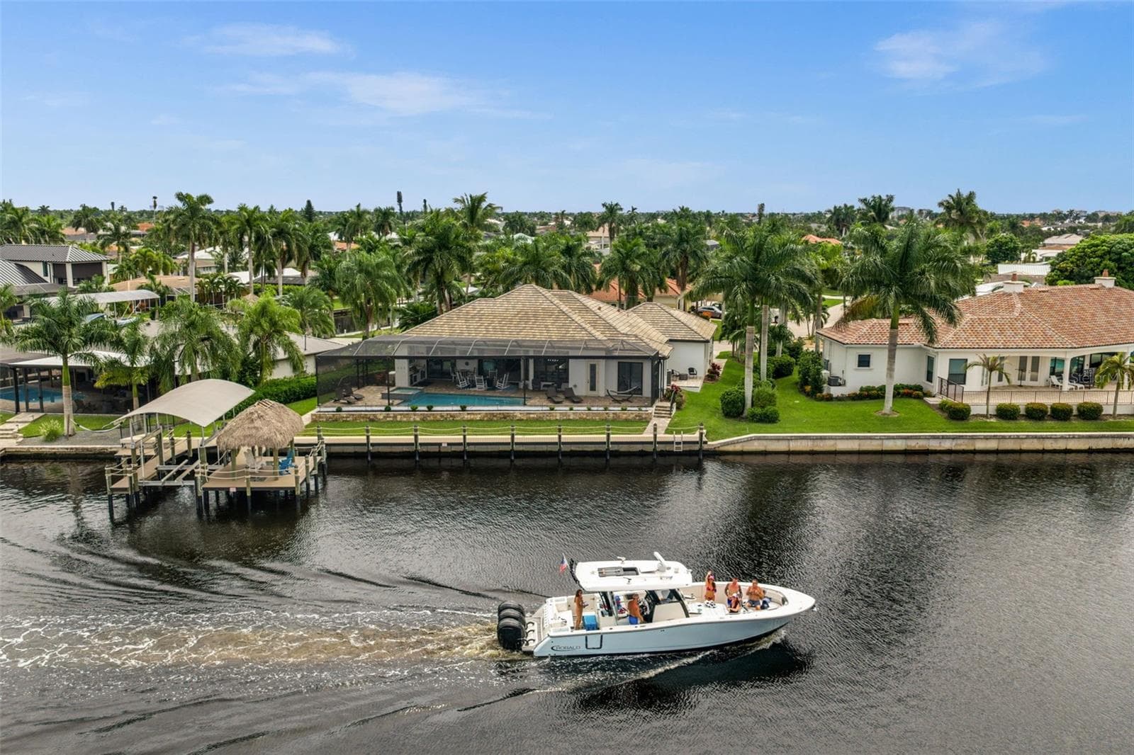 Aerial rear view of the house and dock - 5205 SUNSET CT, CAPE CORAL