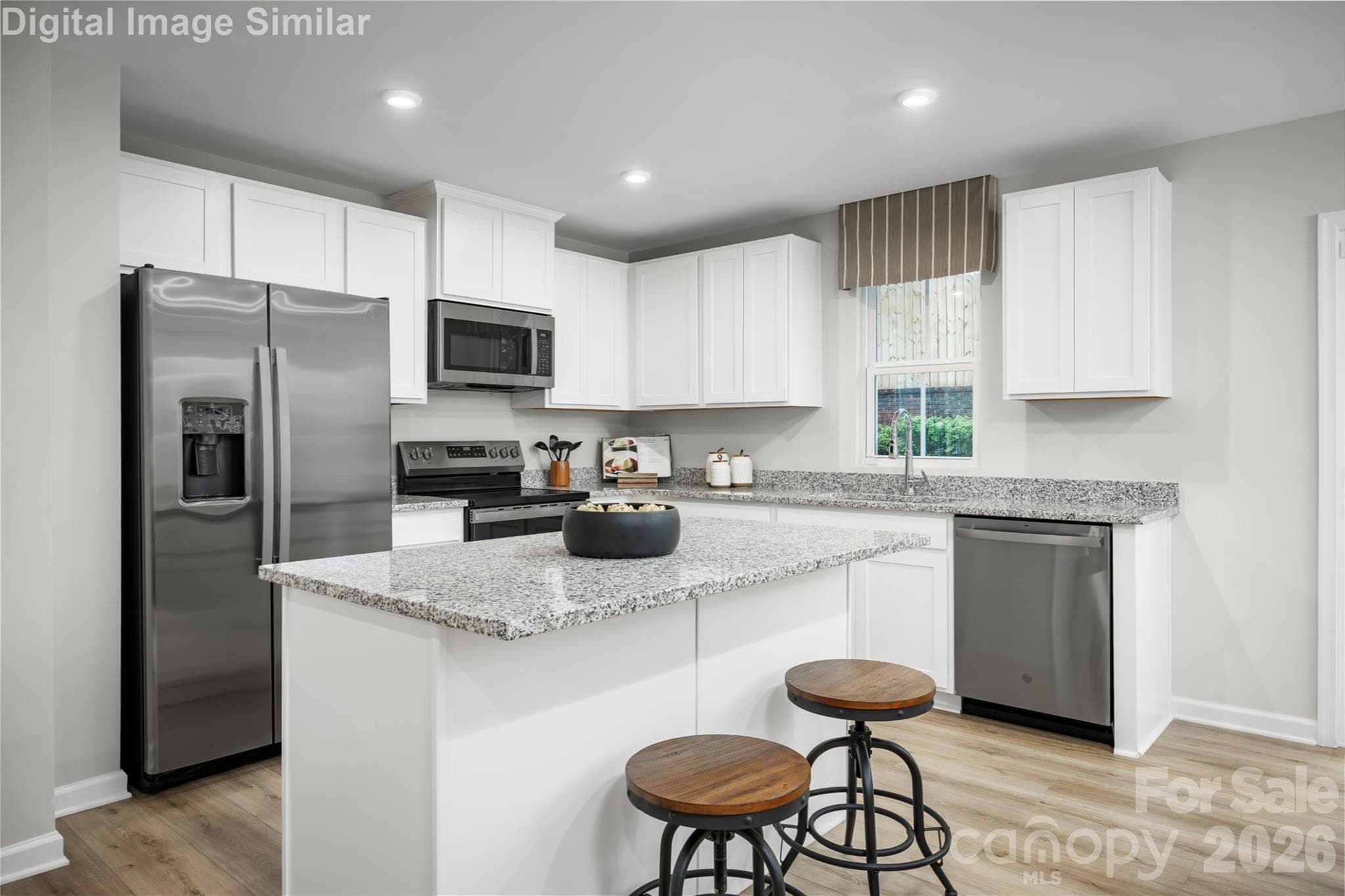 Kitchen goals! Wide-open layout, sleek appliances, and stylish 36" cabinets—where elegance meets everyday ease - 5219 Macvittie Lane, Charlotte