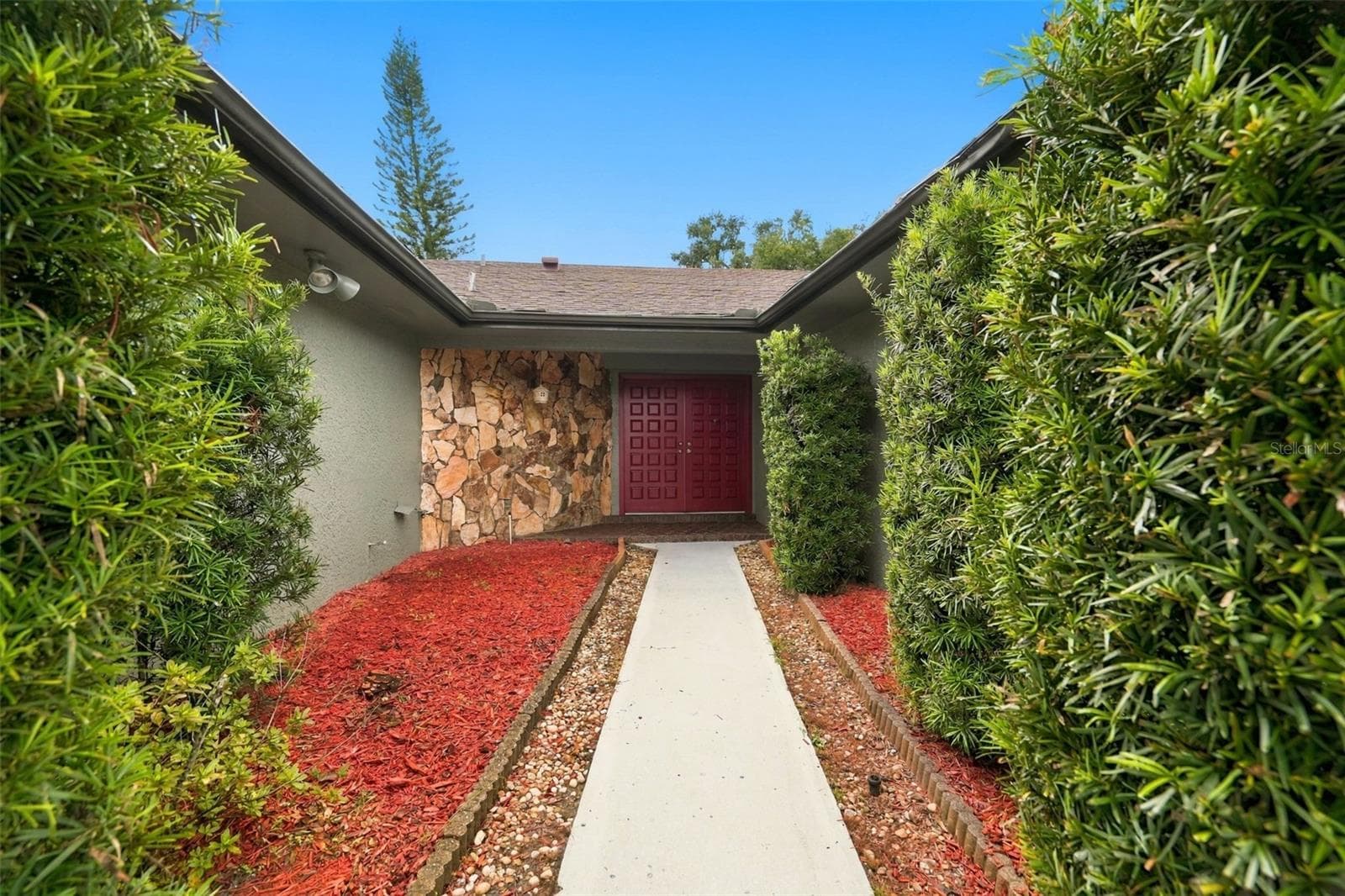 A sandstone-accented courtyard and foyer connect to a generously sized living and dining area. - 1297 PEACH TREE DR, DUNEDIN
