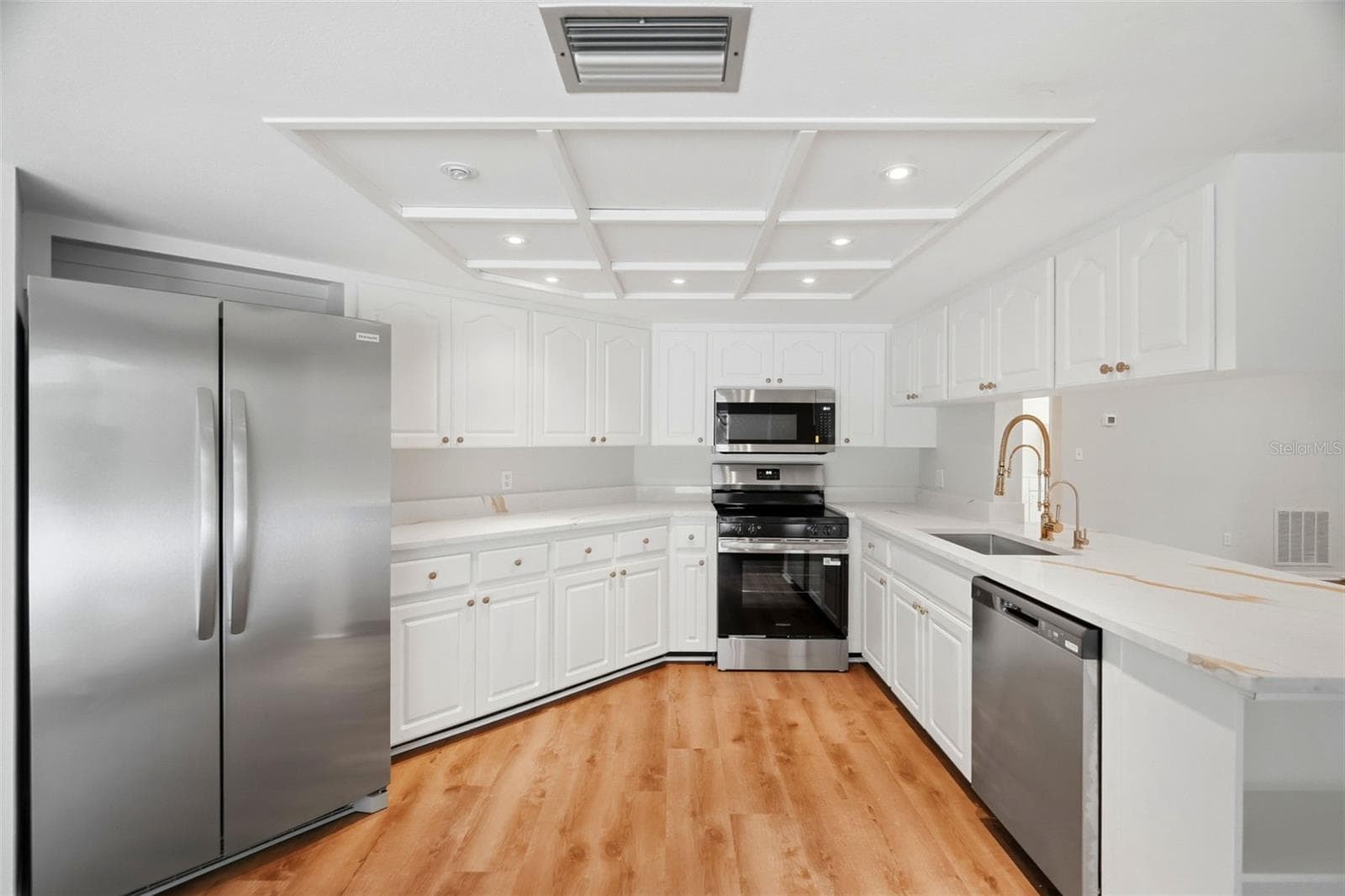 Recently refreshed with new quartz countertops, fixtures, and painted wood cabinetry. - 1297 PEACH TREE DR, DUNEDIN