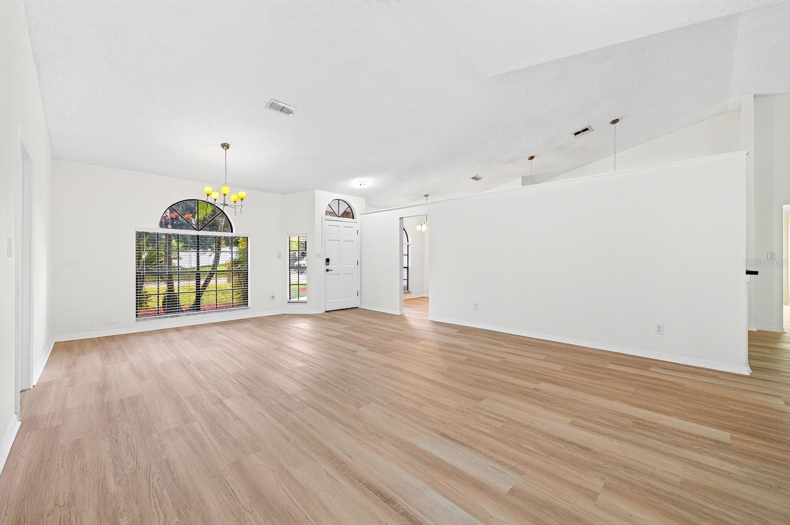 Located in a desirable GOLF COMMUNITY with a LOW HOA, this home makes a great first impression and welcomes you inside with soaring vaulted ceilings and NEW LVP FLOORING THROUGHOUT (2026), creating a fresh, cohesive feel. - 1003 N MAGEE CREEK CT, OVIEDO