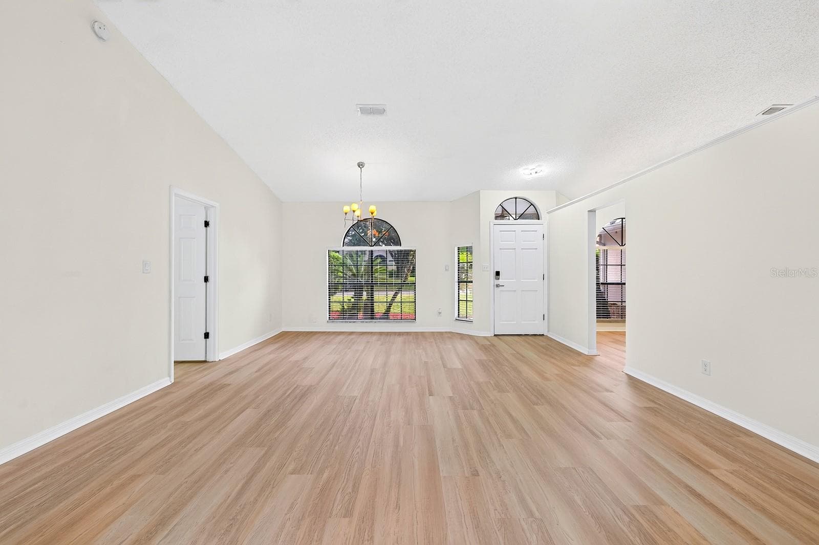 The formal Dining Room features an ELEGANT ARCHED LUNETTE WINDOW and flows into the Living Room. - 1003 N MAGEE CREEK CT, OVIEDO