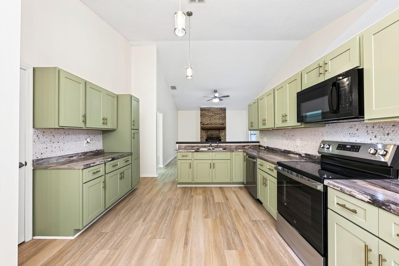 The beautifully REFRESHED KITCHEN offers an abundance of NEW CABINETRY and counter space, a convenient breakfast bar and NEW STAINLESS STEEL APPLIANCES. - 1003 N MAGEE CREEK CT, OVIEDO