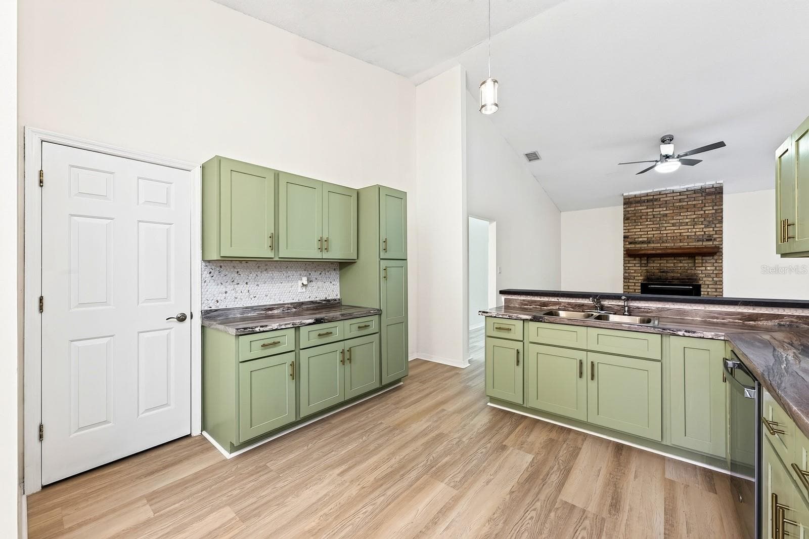 The beautifully REFRESHED KITCHEN offers an abundance of NEW CABINETRY and counter space, a convenient breakfast bar and NEW STAINLESS STEEL APPLIANCES. - 1003 N MAGEE CREEK CT, OVIEDO