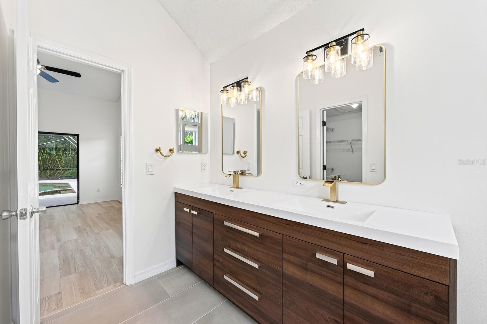 The Primary en suite Bath has been COMPLETELY UPDATED IN 2026 with dual sinks, a garden tub, a step-in shower and stylish MARBLE-LOOK tile walls. - 1003 N MAGEE CREEK CT, OVIEDO