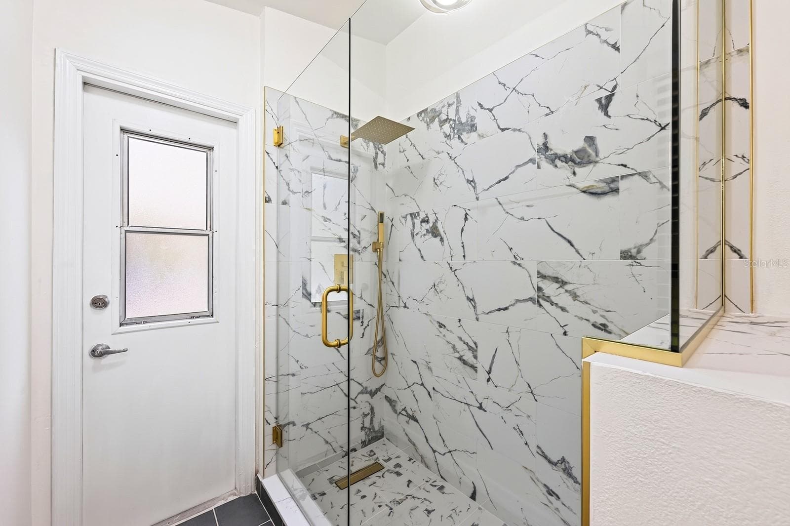 The second full Bath, also COMPLETELY UPDATED IN 2026, features dual sinks, a walk-in shower and a convenient door leading directly to the pool area. - 1003 N MAGEE CREEK CT, OVIEDO