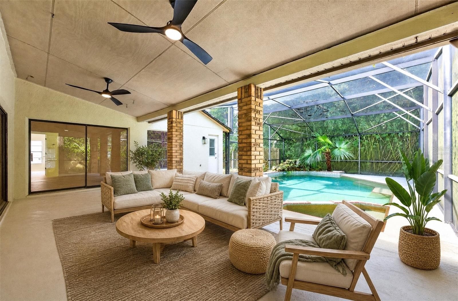 Sliding doors from the Family Room, Living Room and Primary Bedroom lead to the patio. Virtually Staged - 1003 N MAGEE CREEK CT, OVIEDO