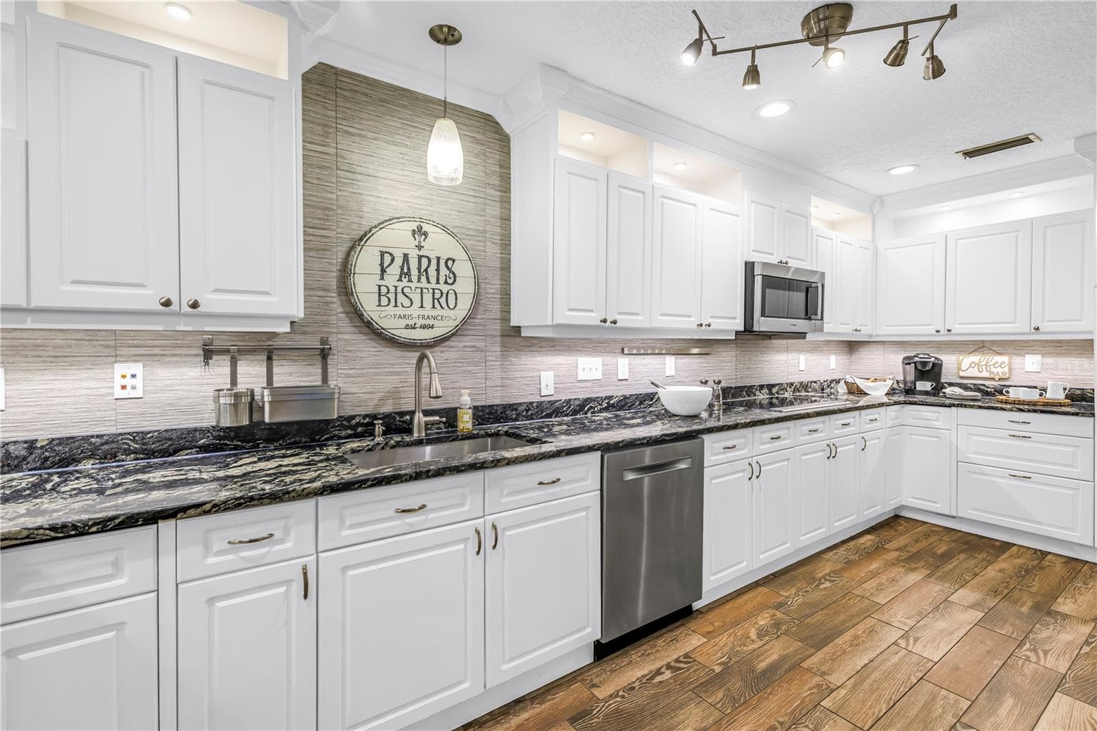 This spacious gourmet kitchen features high-end granite countertops, premium stainless steel appliances, and an elegantly designed backsplash. - 146 GIRALDA BLVD NE, ST PETERSBURG