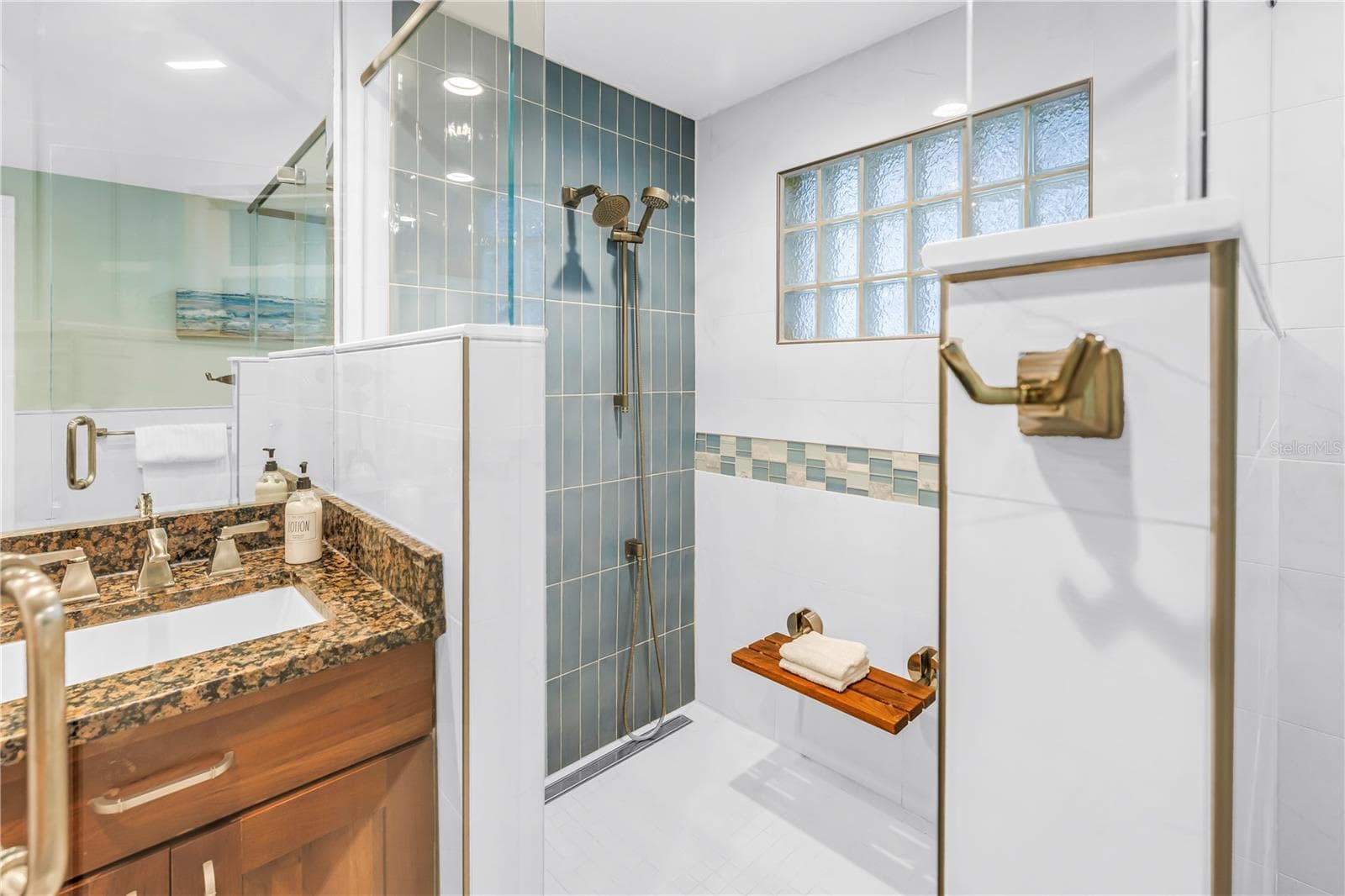 Exquisite spa-inspired walk-in shower featuring a built-in bench and a handheld shower wand. - 146 GIRALDA BLVD NE, ST PETERSBURG