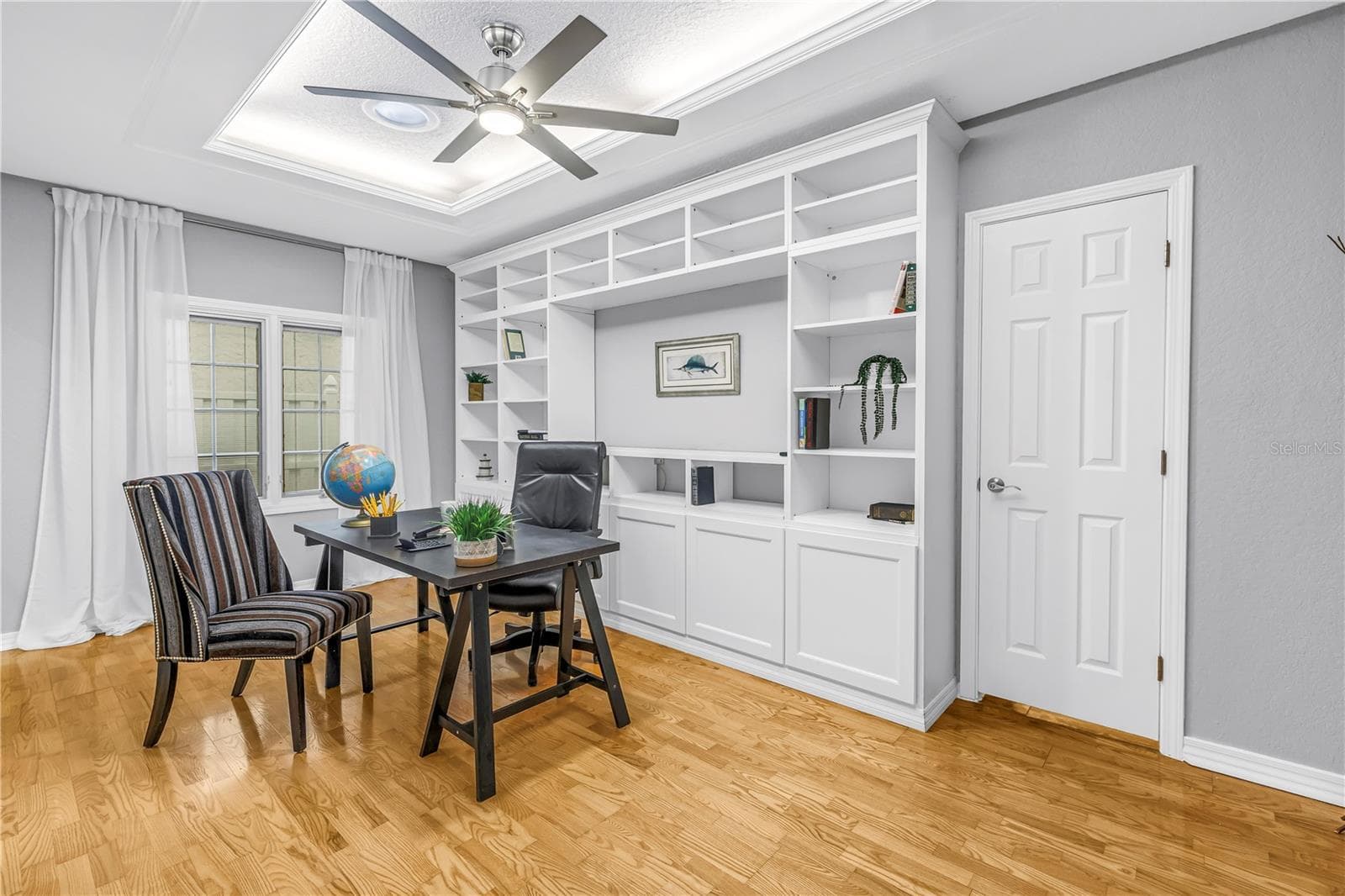 The fourth bedroom features direct access to the hallway bathroom and includes a built-in credenza. The space offers privacy while remaining connected to the main living area through elegant glass French doors. - 146 GIRALDA BLVD NE, ST PETERSBURG
