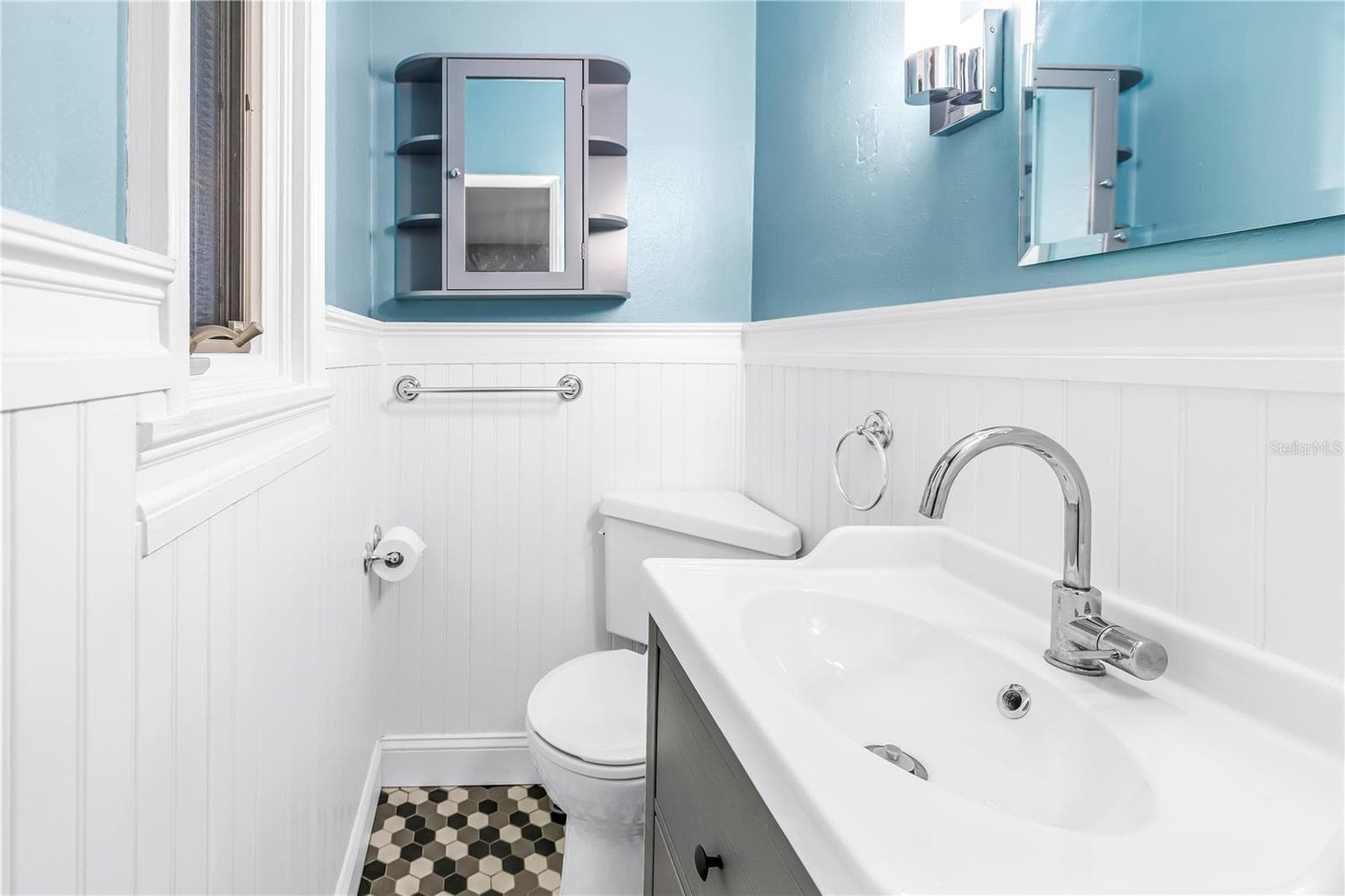 This is the second bedroom's half bath, featuring charming beadboard paneling and elegant fixtures. - 146 GIRALDA BLVD NE, ST PETERSBURG