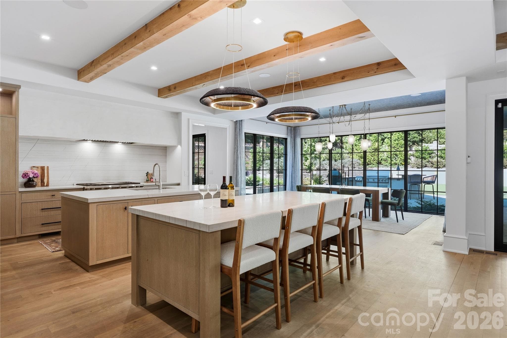 The kitchen opens to a large dining space with floor to nearly ceiling windows. - 2610 Sedley Road, Charlotte