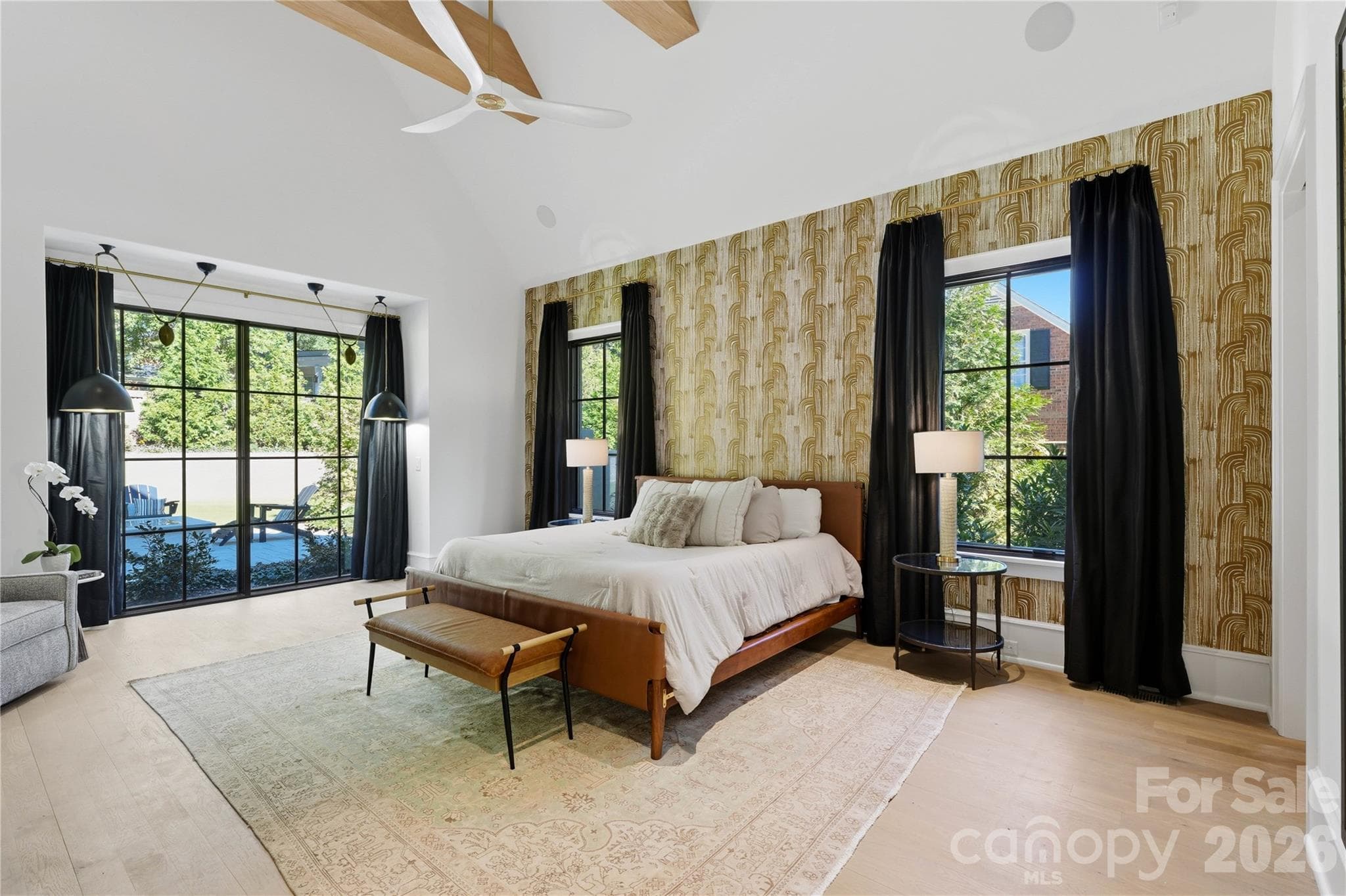 Primary bedroom with vaulted ceilings and large windows overlooking the backyard. - 2610 Sedley Road, Charlotte
