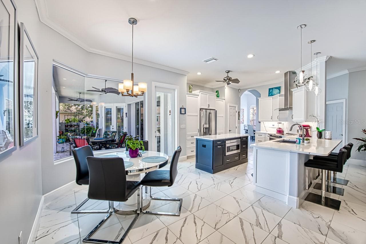 Dinette in Kitchen/Family room area.  Tile floor throughout the home.  Single height counter with seating - 8625 SOUTHWIND BAY CIR, FORT MYERS