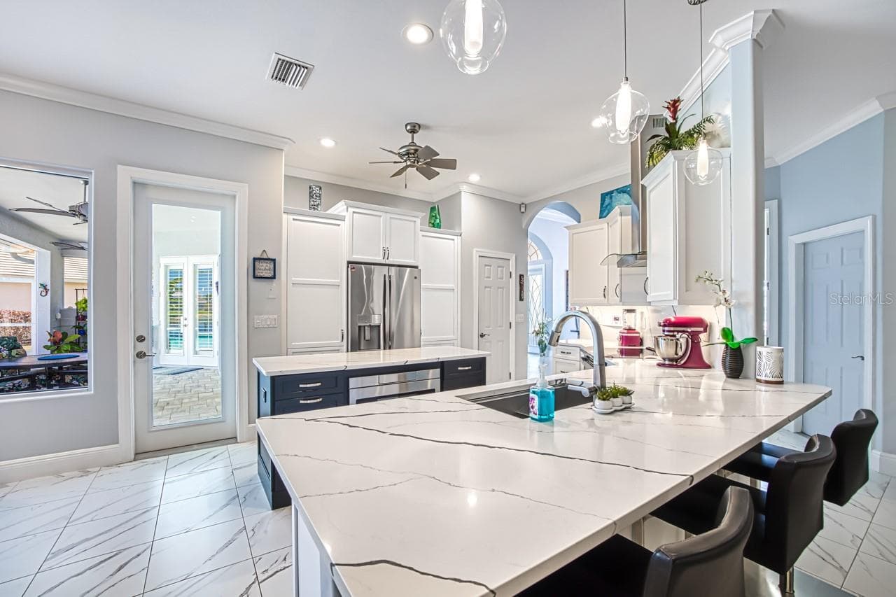 Kitchen opens to family room with fireplace - 8625 SOUTHWIND BAY CIR, FORT MYERS