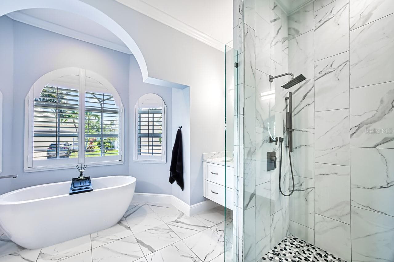 Updated primary bath with walk in shower and separate tub.  Wall mounted vanities - 8625 SOUTHWIND BAY CIR, FORT MYERS