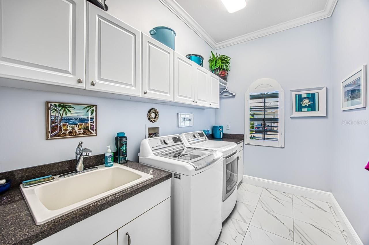 Laundry room with utility sink and storage cabinets - 8625 SOUTHWIND BAY CIR, FORT MYERS