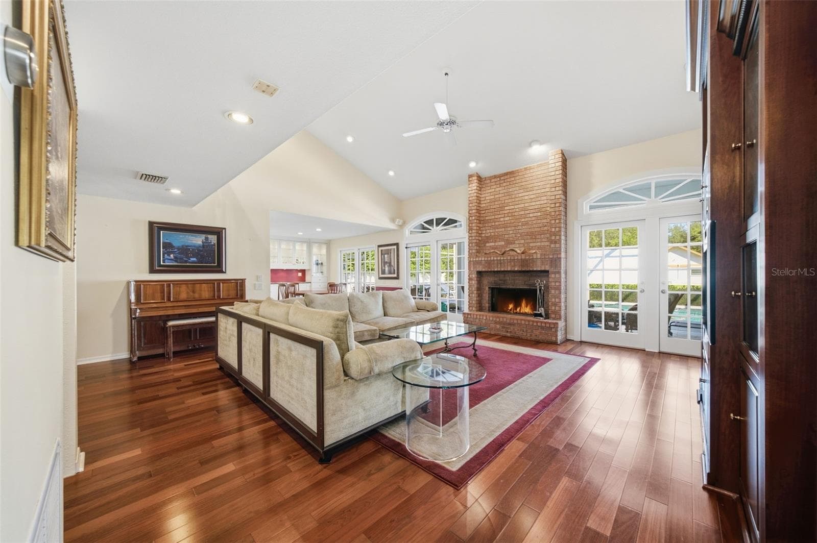 Great Room offering 14' ceilings, wood flooring and a wood-burning fireplace. - 12383 WINDTREE BLVD, SEMINOLE