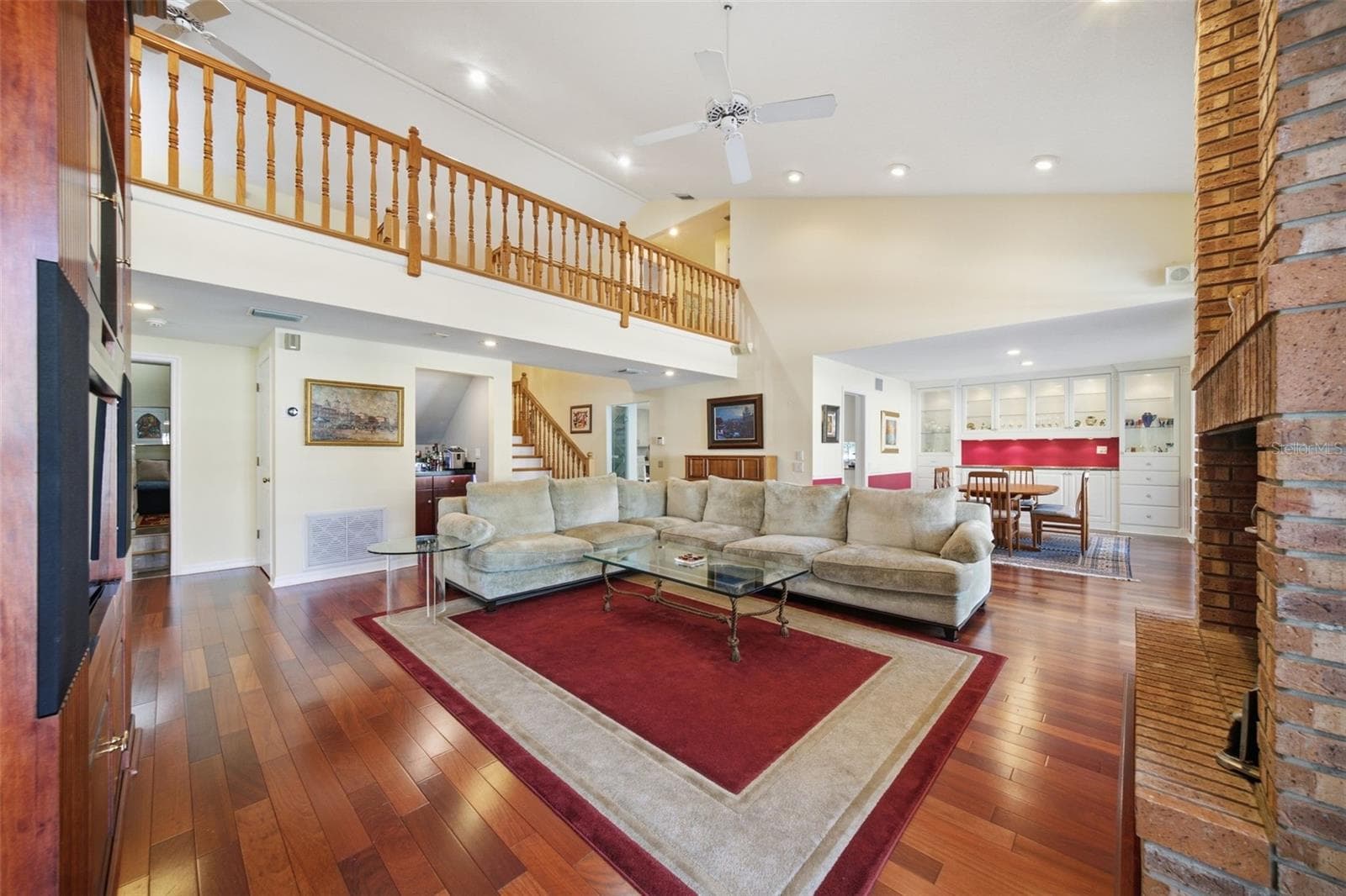 Expansive Family Room with a view of the Dining Room and second floor gallery. Wood-burning brick fireplace - 12383 WINDTREE BLVD, SEMINOLE