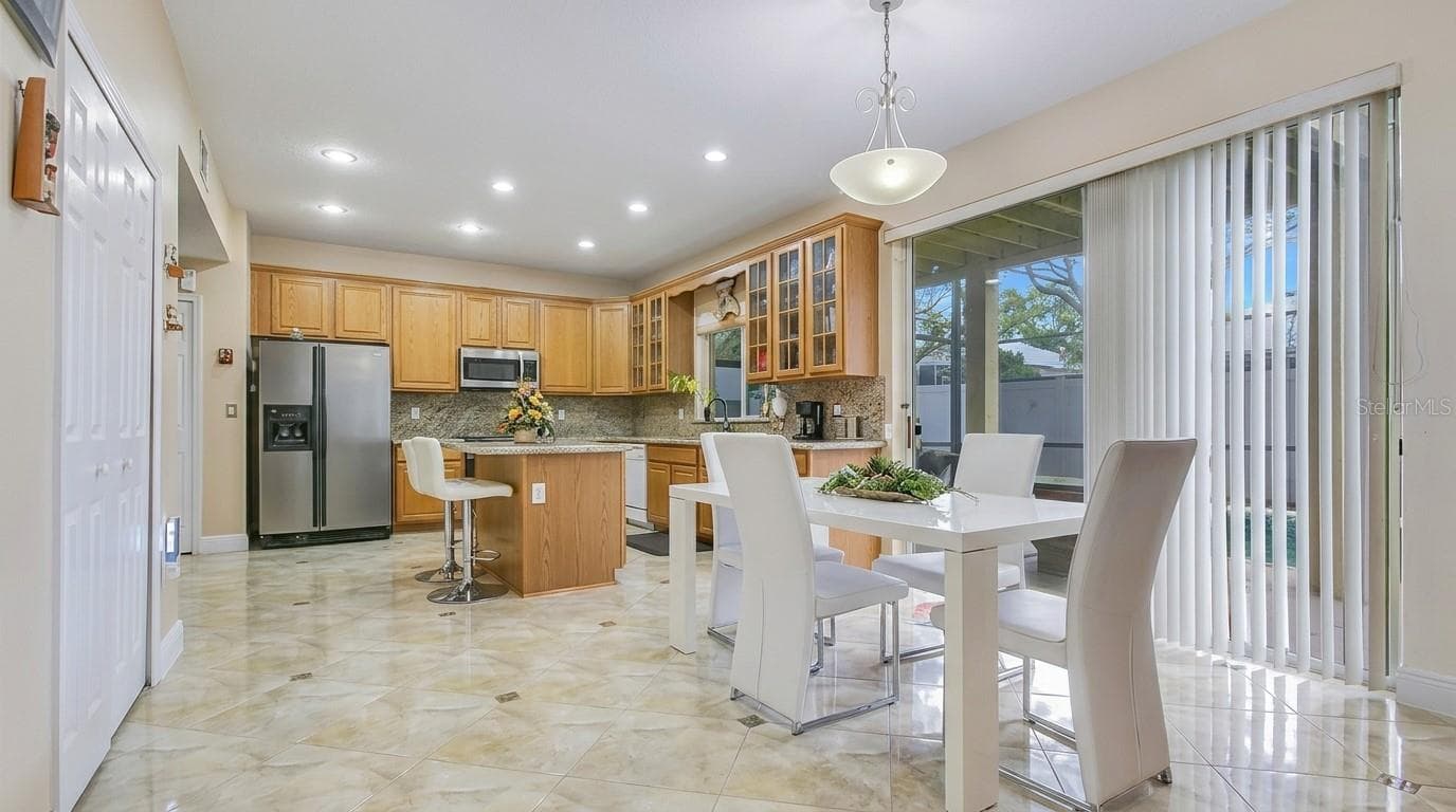 Sliding glass door leading from the kitchen to the pool area. - 7866 BARDMOOR HILL CIR, ORLANDO